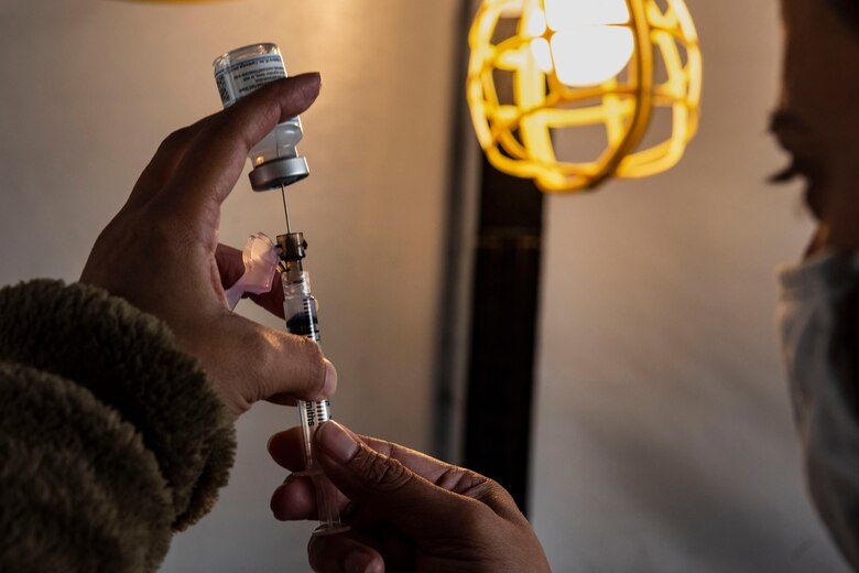 Airman preparing a syringe.