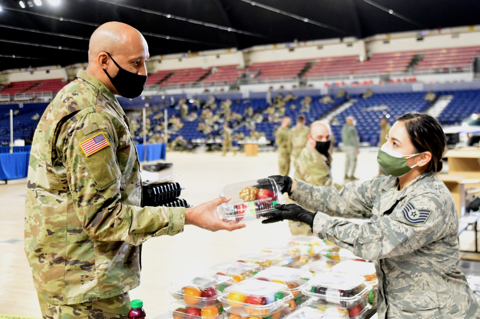 Tech. Sgt. Jennifer Zamudio, a member of the District of Columbia Air National Guard, distributes a meal to a Soldier at the D.C. National Guard Armory, Washington, D.C., Jan. 10, 2021. National Guard officials are stressing that the Soldiers and Airmen from all 50 states, three territories and Washington are receiving adequate food and lodging as they continue to support federal and local authorities leading up to the 59th presidential inauguration.