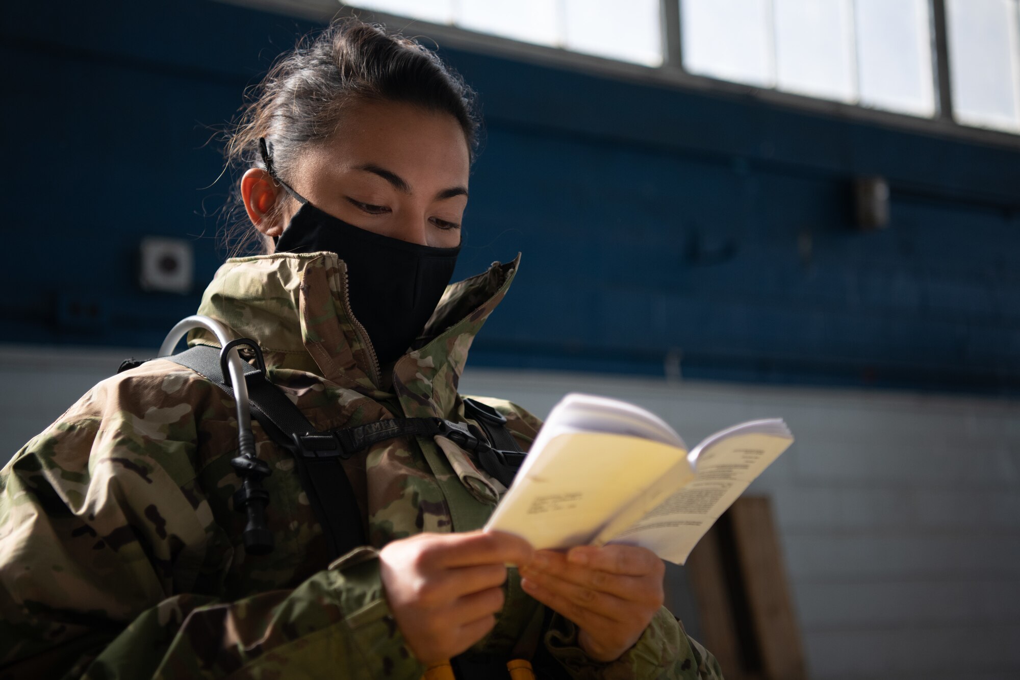2nd Lt. Meggan Tamondong, an officer trainee at Officer Training School, reads an OTS manual while seated in the post-vaccination waiting area Jan. 16, 2020, at the off-site clinic in the Honor Guard hangar on Maxwell Air Force Base, Alabama. Patients were asked to remain in the hangar for an additional 30 minutes after receiving the vaccine so they could alert nursing staff if they had any concerns.