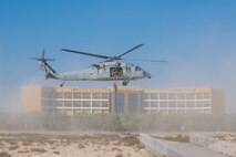 210113-N-KZ419-1175 U.S. 5TH FLEET AREA OF OPERATIONS (Jan. 13, 2021) Bahrain Defense Force personnel fast rope from a helicopter during a joint anti-terrorism exercise with U.S. Naval Forces Central Command in the U.S. 5th Fleet area of operations, Jan. 13. The bilateral exercise focused on enhancing mutual security and anti-terrorism capabilities by testing responses to simulated scenarios. (U.S. Navy photo by Mass Communication Specialist 3rd Class Dawson Roth)