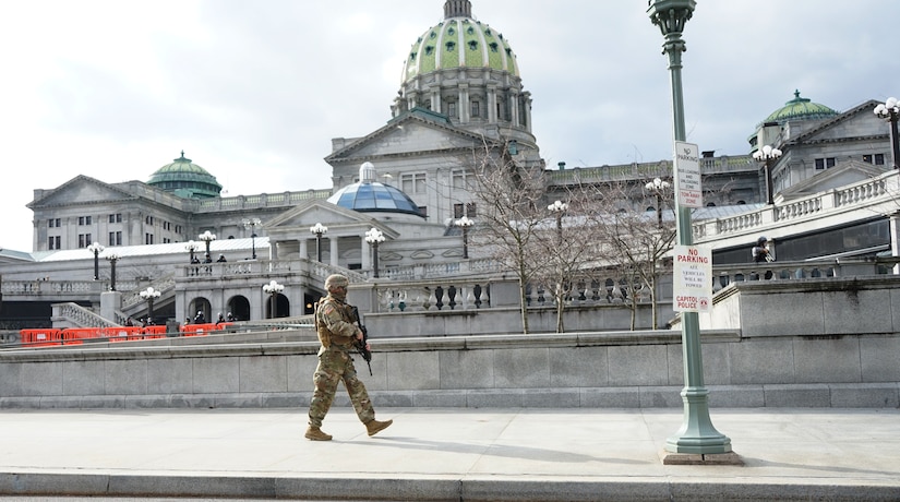 A Soldier from 1st Battalion, 109th Infantry Regiment, Pennsylvania National Guard, walks along his patrol at the capitol complex in Harrisburg, Pa., on Jan. 17, 2021.
