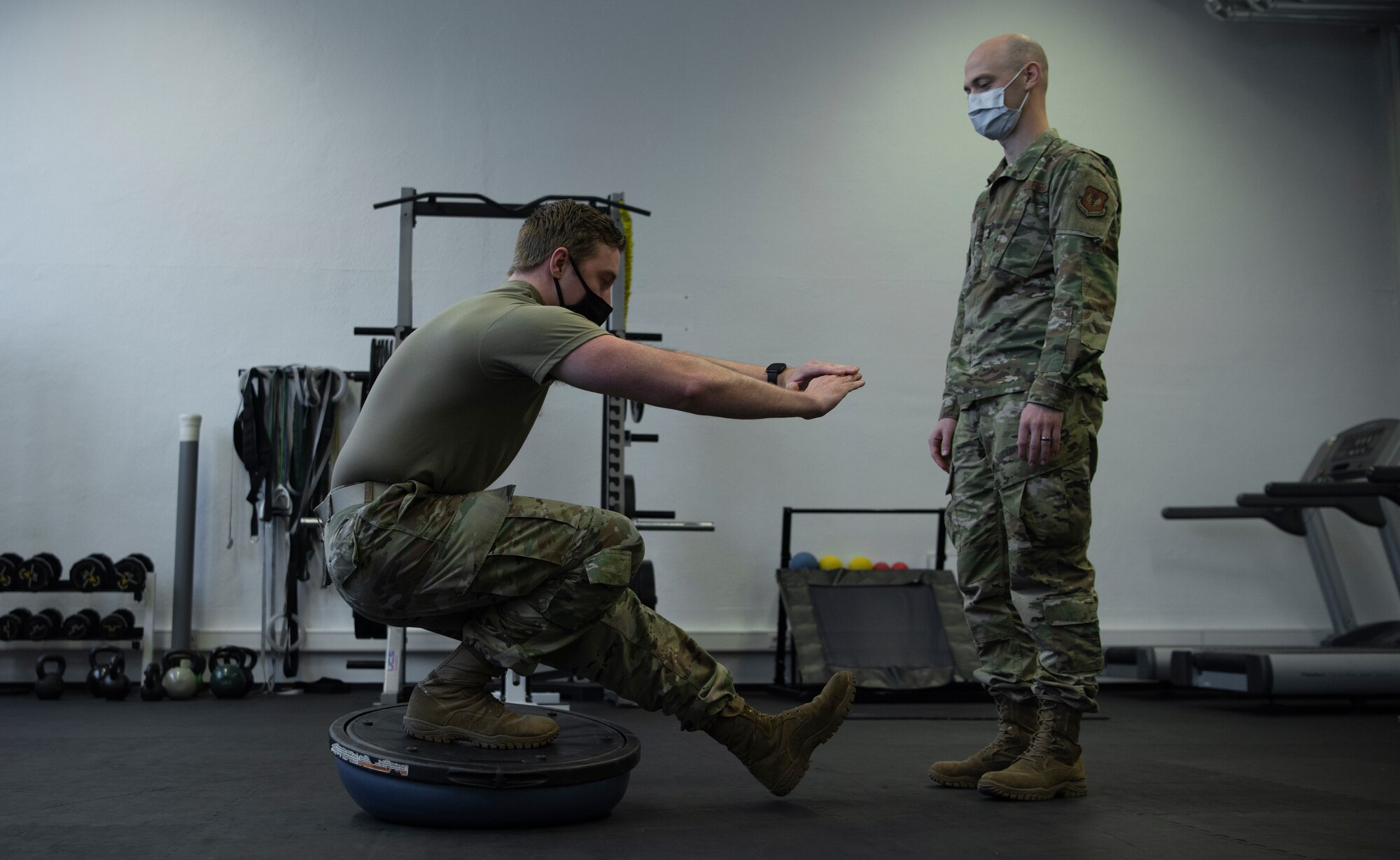 U.S. Air Force 1st Lt. Spencer Carrier, 86th Operational Medical Readiness Squadron physical therapist, watches Staff Sgt. Randy Sayer, 86th OMRS physical therapy technician, balance on a BOSU ball at Ramstein Air Base, Germany, Jan. 13, 2021.