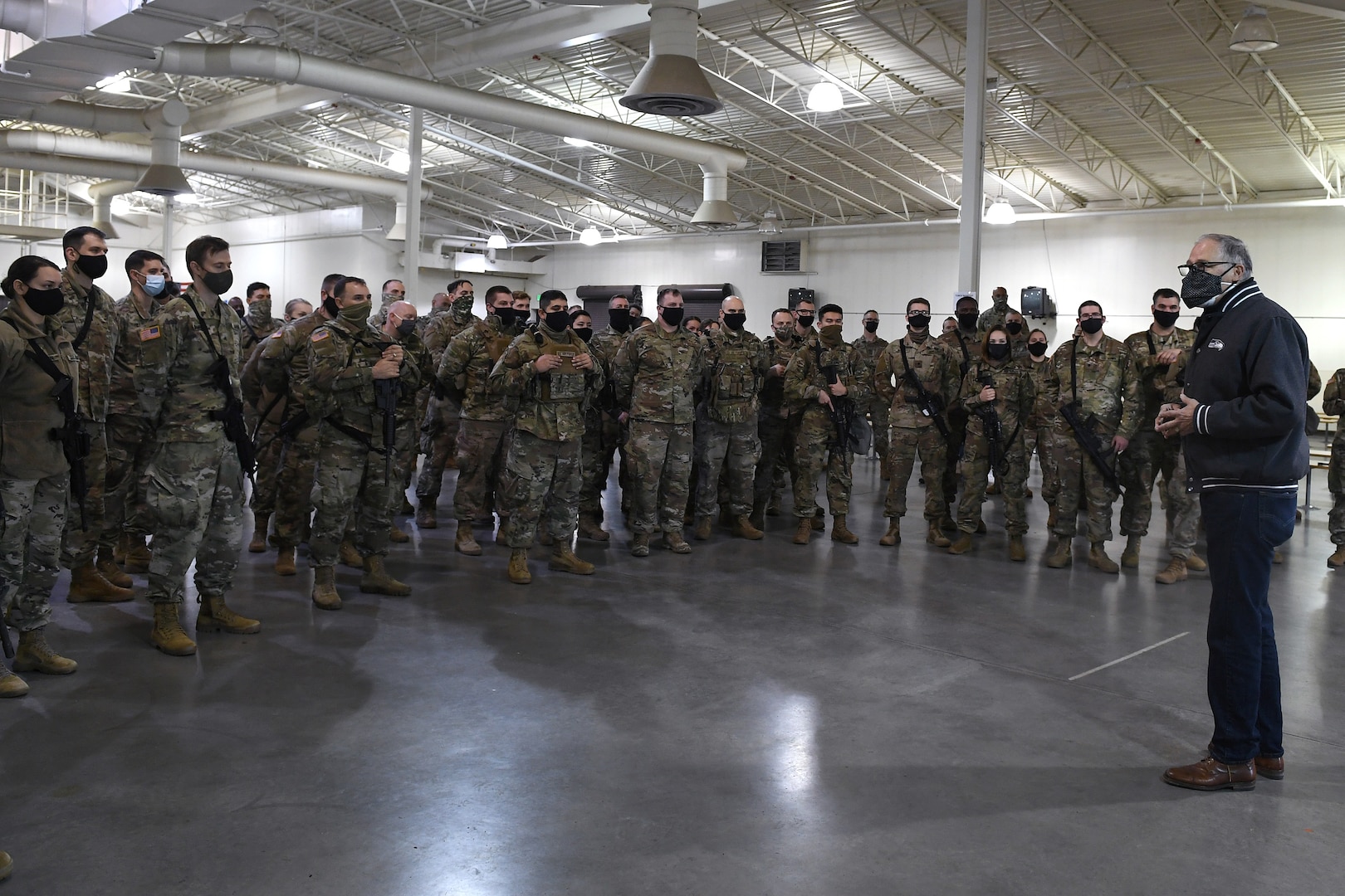 Gov. Jay Inslee speaks to members of the Washington National Guard Jan., 17, 2021, at Joint Base Lewis-McChord, Wash., before their departure to Washington, D.C., to support the presidential inauguration. They are among 25,000 Guard members who are in the District of Columbia from all 50 states, three territories and D.C.