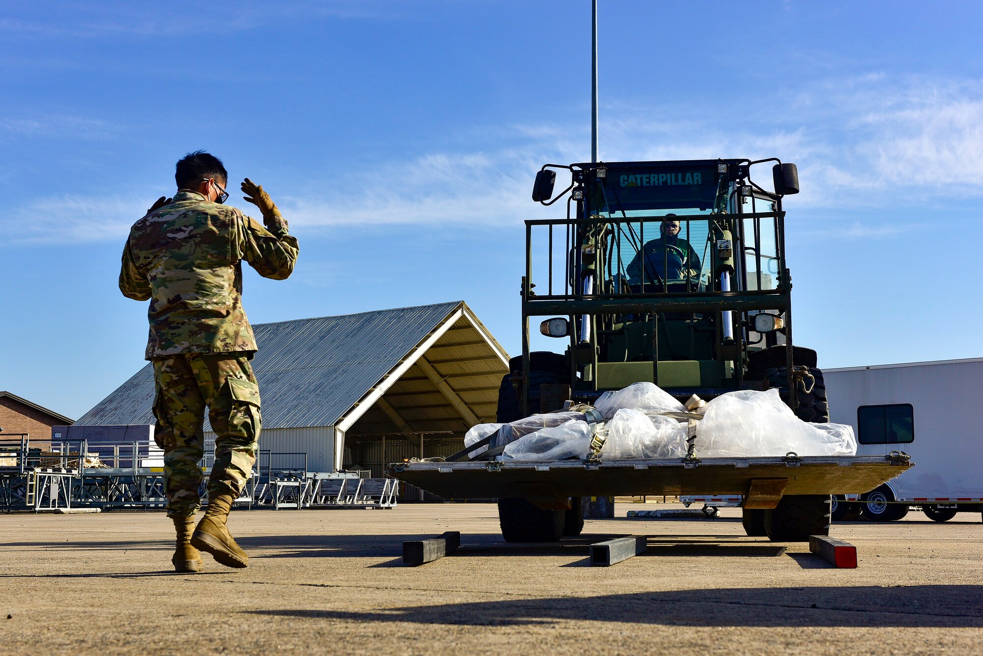 A person directs a forklift operator