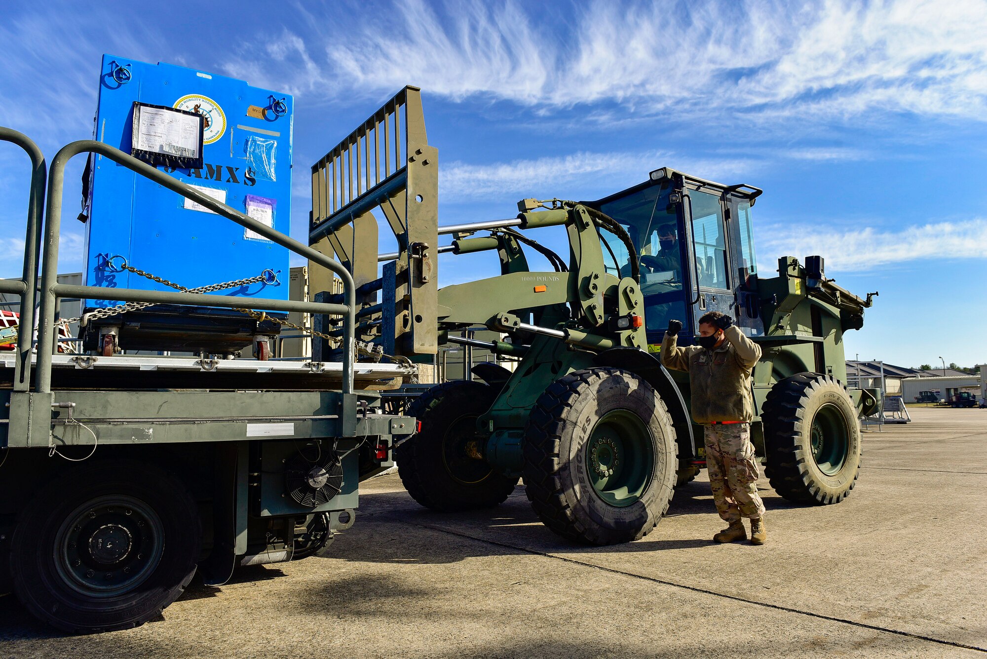 A person directs a forklift operator