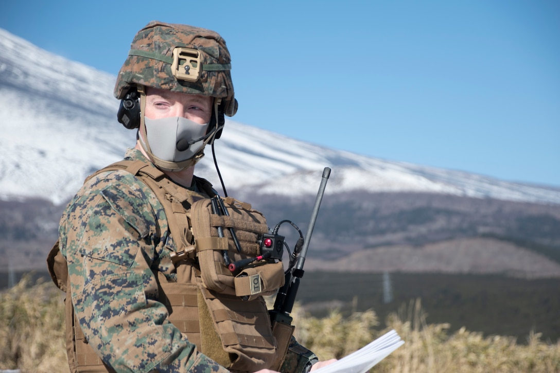 A U.S. Marine relays information to onlookers while observing fixed wing close air support training at Combined Arms Training Center Camp Fuji, Japan, Jan. 14.