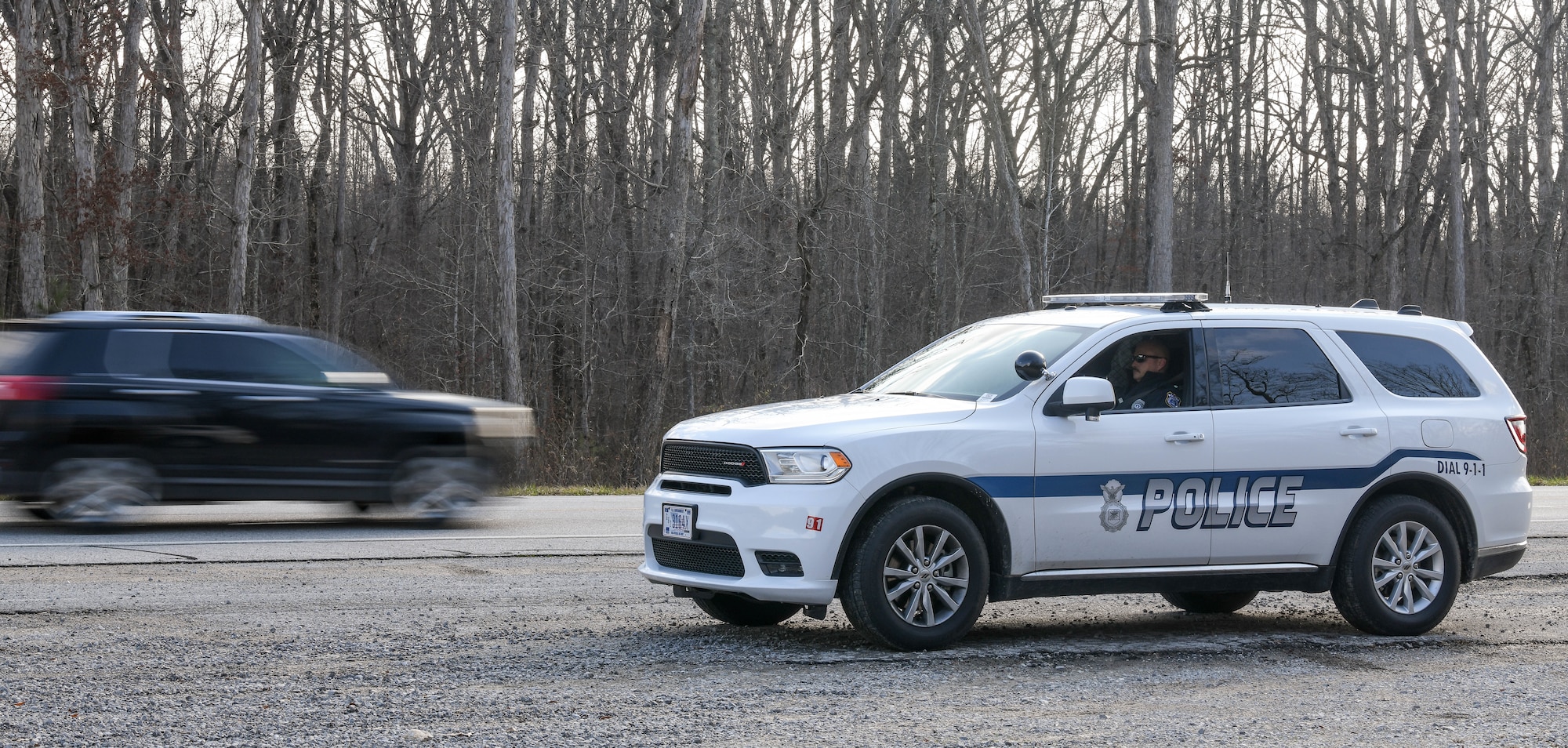 Sgt. George Blasingame, a Dept. of the Air Force Police Officer at Arnold Air Force Base, Tenn., parks at a pull-off along Wattendorf Highway to watch for motorists committing moving violations, Dec. 17, 2020. DAF Officers began patrolling Arnold in late August. The SUV driven by Blasingame was recently acquired for the new force, and another SUV is also on order. Motorists traveling Arnold AFB roadways should be mindful that the DAF officers can issue citations for moving violations. Motorists who are cited for moving violations on Arnold AFB property are assessed points. Points are entered into the Air Force Justice Information System and assessed against their on-base driving record. Accumulation of 12 points in 12 months or 18 points in 24 months normally results in loss of driving privileges for up to a year. If someone gets caught driving during their revocation period, an additional year is usually added to the penalty. (U.S. Air Force photo by Jill Pickett)