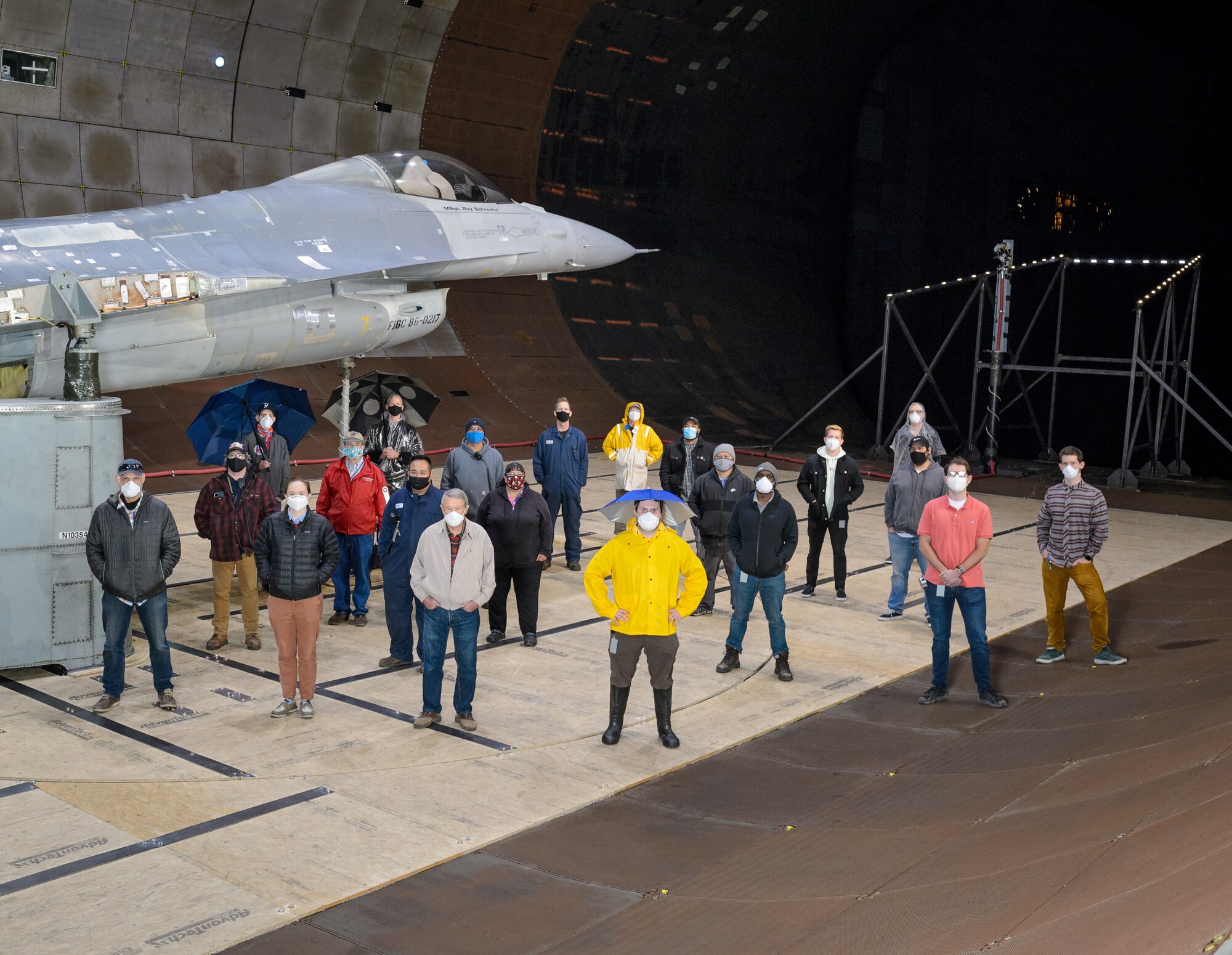 The test team for the F-16 canopy water pooling visibility test stand beside the test article in the Arnold Engineering Development Complex National Full-Scale Aerodynamics Complex 40- by 80-foot test section, Dec. 1, 2020. (NASA photo by Dominic Hart)(This image has been altered by obscuring badges for security purposes.)