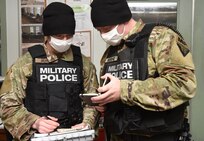 Cpl. Aiden Flynn and Spc. Jamie Burdge compare notes while investigating a stolen cell phone during a training exercise Jan. 16, 2021, at the Camp Ethan Allen Training Site in Jericho, Vermont. Flynn and Burdge are military policemen with the 172nd Law Enforcement Detachment, which is training in preparation for a deployment to support U.S. Army Europe and Africa. (U.S. Army National Guard photo by Don Branum)