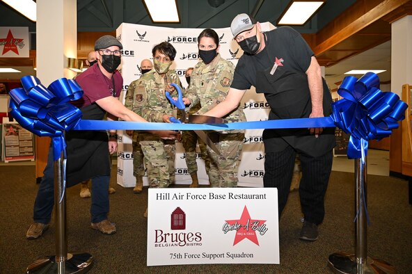 (Left to right) Frederic Bosteels, Bruges Belgian Bistro owner, Col. Jenise Carroll, 75th Air Base Wing commander, Lt. Col. Summer Lewis, 75th Force Support Squadron commander, and Jason Greer, Smoke-A-Billy BBQ & Grill owner, cut a ceremonial ribbon.