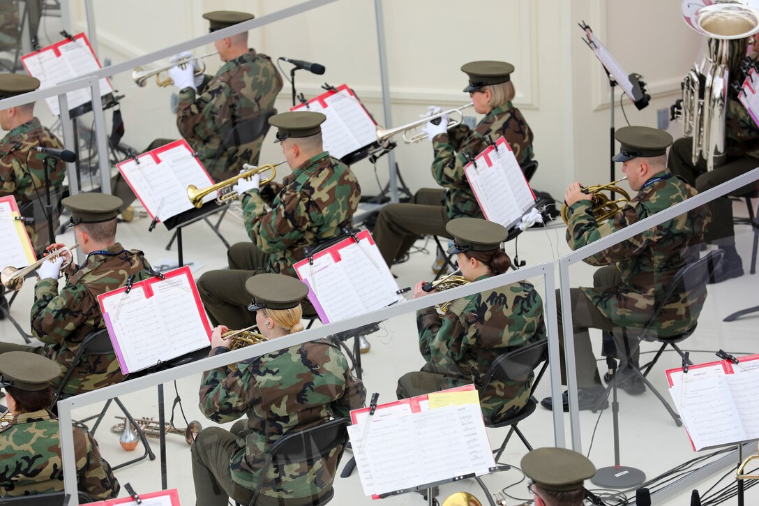 Uniformed service members play musical instruments.