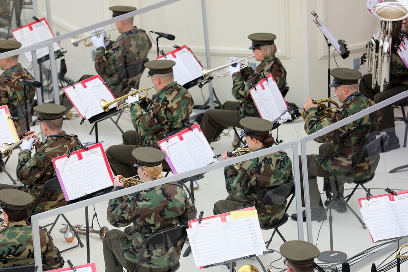 Uniformed service members play musical instruments.