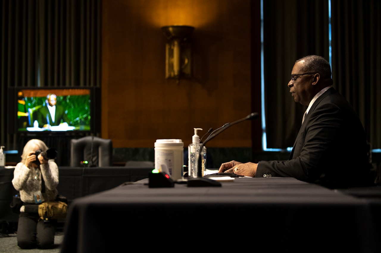 A man sits at a table in a room.