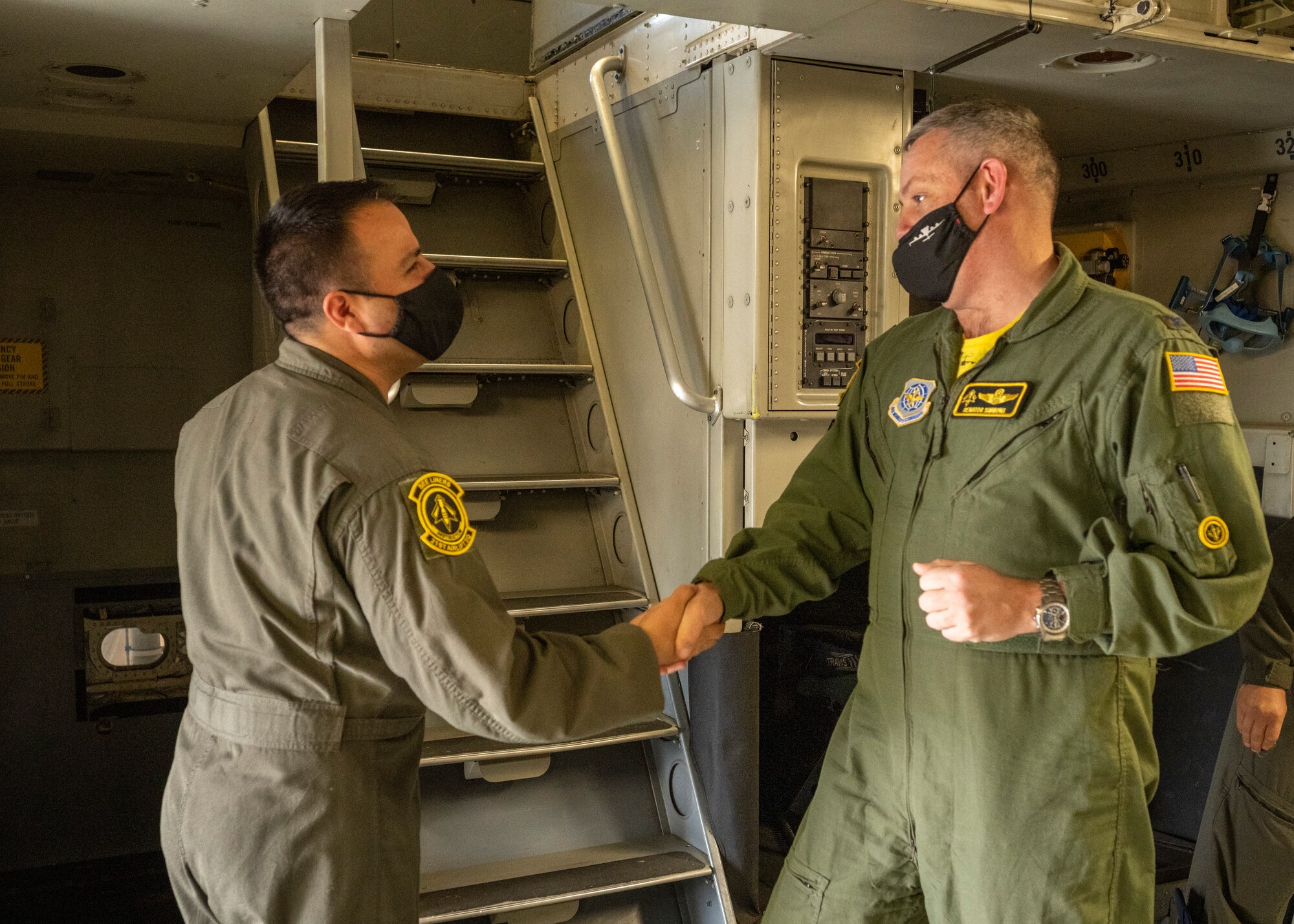Commander shakes Airman's hand and presents a coin