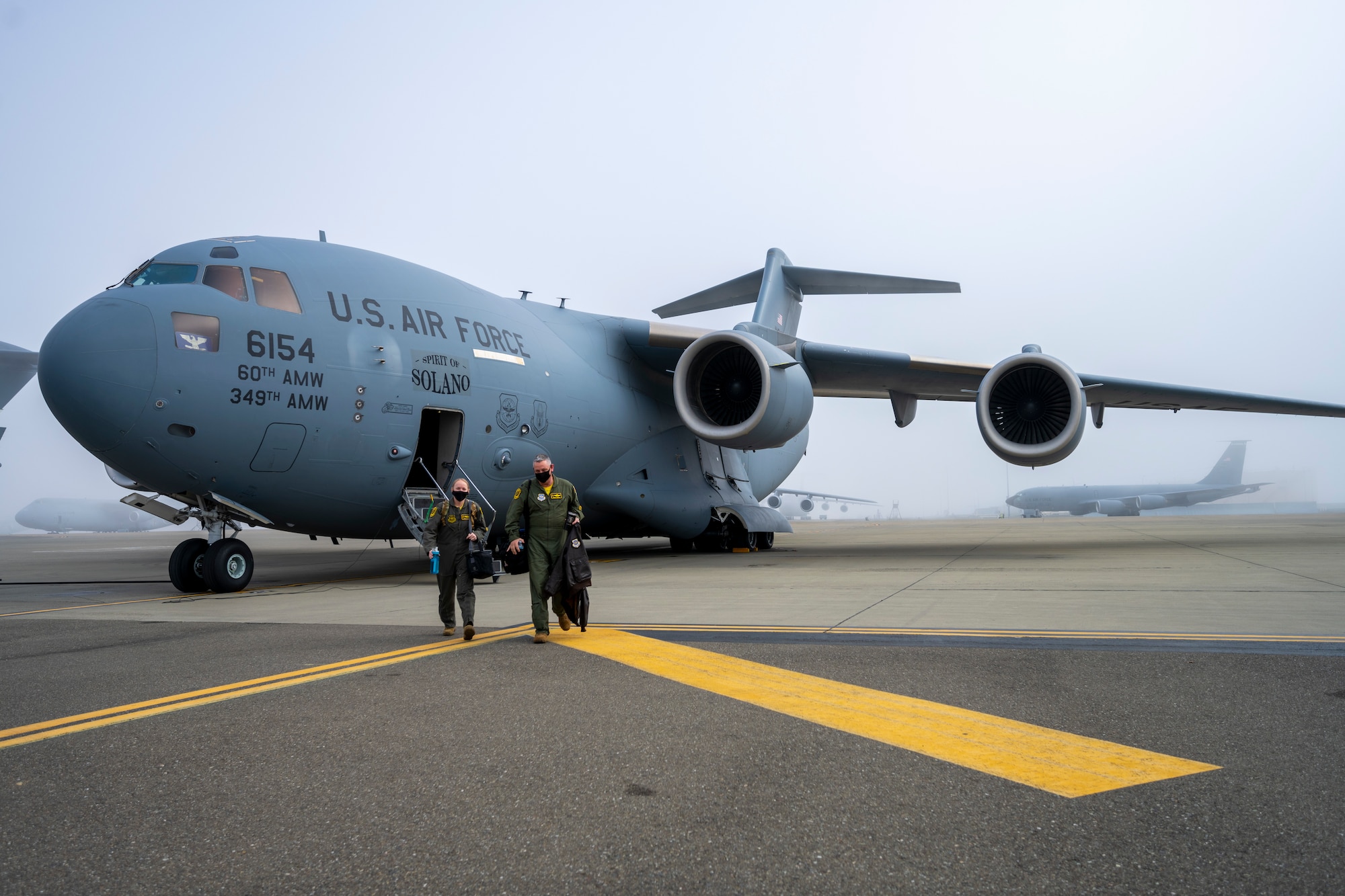 Two Airmen walk away from aircraft on flight line