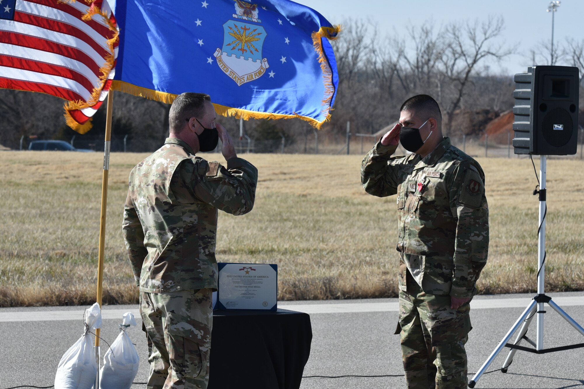 Col. Filcek saluting Tech. Sgt. Lopez during ceremony