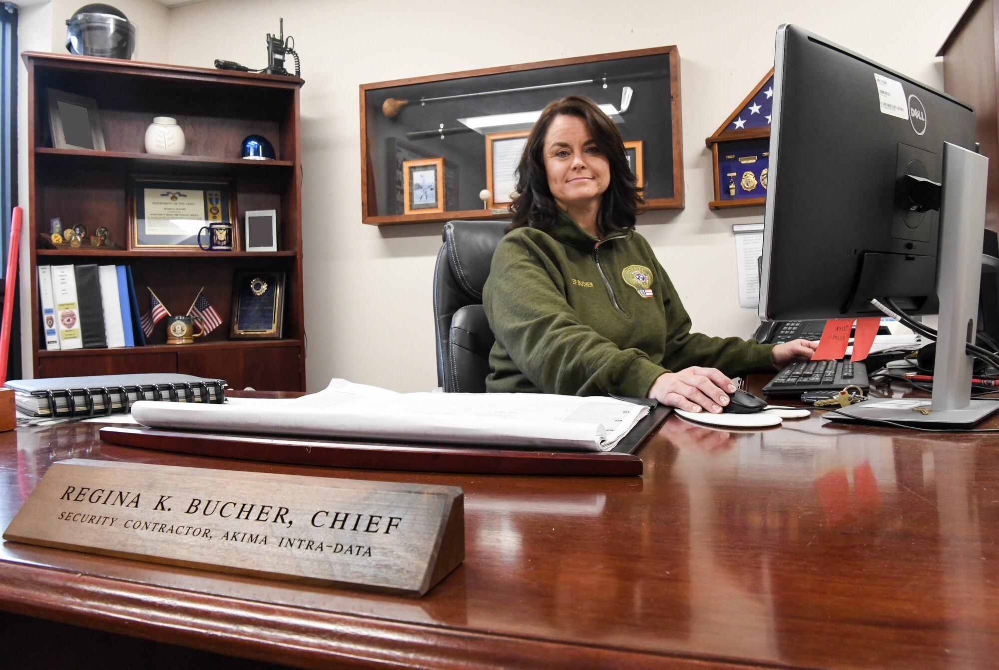 Regina Bucher, the new the new Security Services Supervisor at Arnold Air Force Base, Tenn., sits at her desk Dec. 8, 2020. She is the first female to lead the contractor security section. (U.S. Air Force photo by Jill Pickett) (This image was altered by obscuring photos in this image for security reasons.))