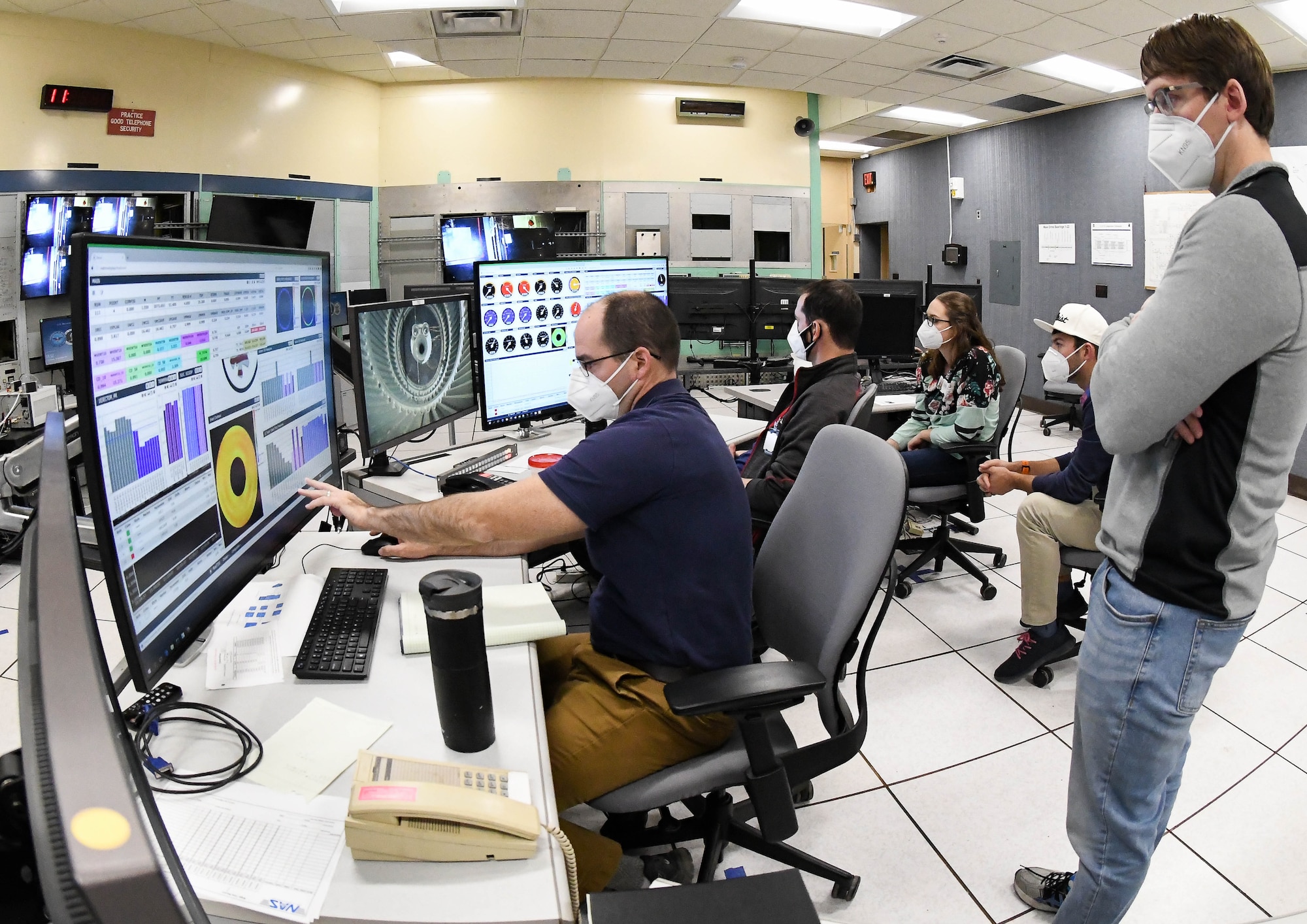 Nathan Payne, left, propulsion subject matter expert for the Flight Systems Test Branch, Test Division, Arnold Engineering Development Complex, watches data as it is collected during a test run in the 16-foot supersonic wind tunnel to calibrate a mass flow assembly, Nov. 19, 2020, at Arnold Air Force Base, Tenn. Calibration of large-scale MFAs is a new capability in 16S. Also pictured, Josh Webb, right, Analysis Flight commander, Flight Systems Test Branch. (U.S. Air Force photo by Jill Pickett) (This image has been altered by obscuring a badge for security purposes.)