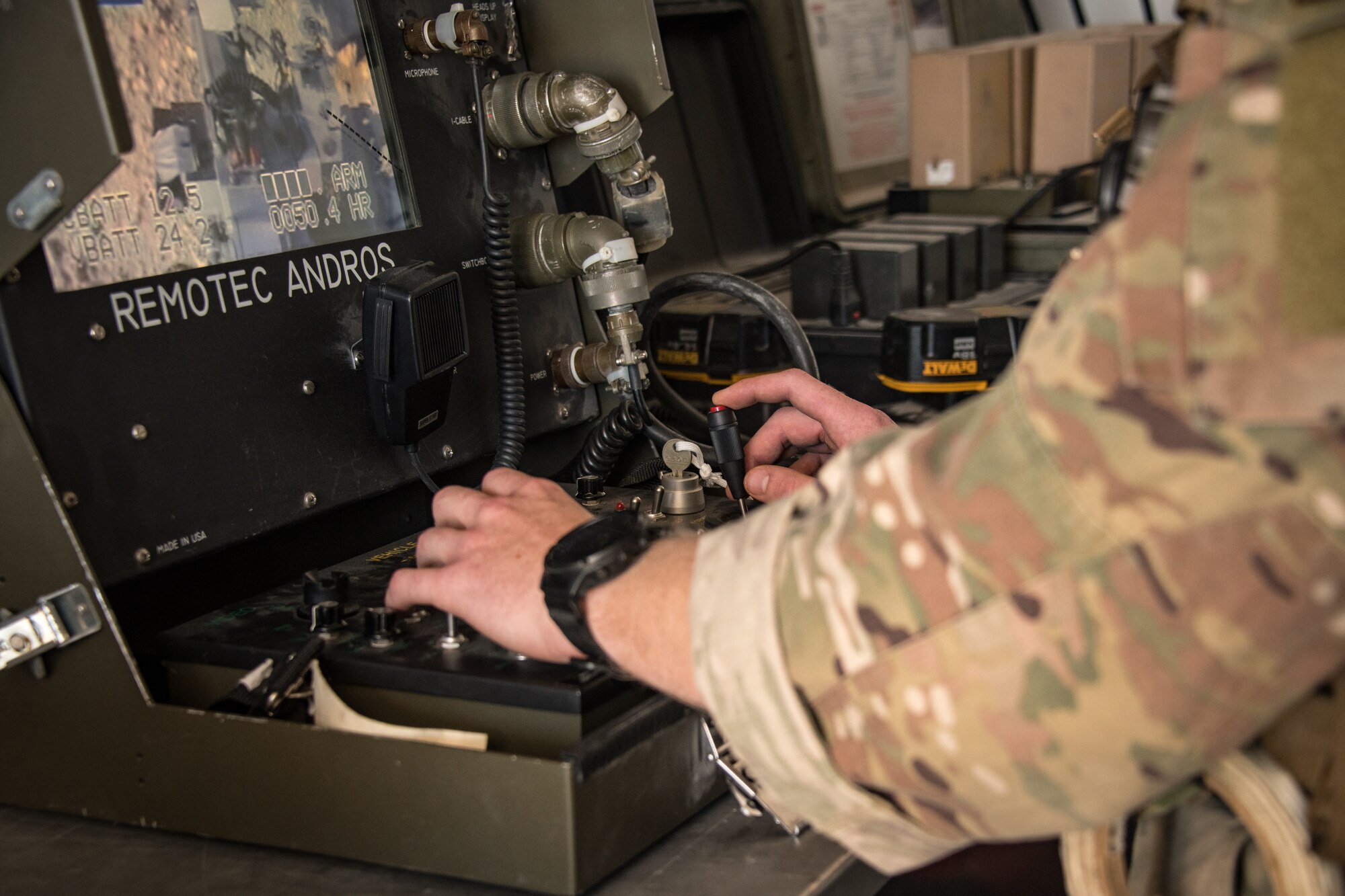 An Airman uses the controls of a remote driving system