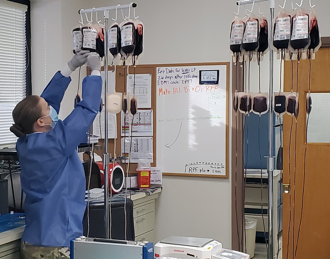 Army Spec. Naomi Plummer, a medical laboratory specialist with the Akeroyd Blood Donor Center at Brooke Army Medical Center, Joint Base San Antonio-Fort Sam Houston, "hangs" units of blood in preparation of removing the white blood cells from the whole blood.