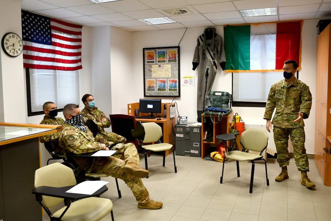 U.S. Air Force Tech. Sgt. Michael Rutland, 31st Operations Support Squadron Survival, Evasion, Resistance and Escape (SERE) noncommissioned officer in charge, right, speaks with U.S. and Italian air force members at Aviano Air Base, Italy, Jan. 19, 2021. SERE specialists teach several survival courses including water, cold weather and combat. (U.S. Air Force photo by Staff Sgt. K. Tucker Owen)