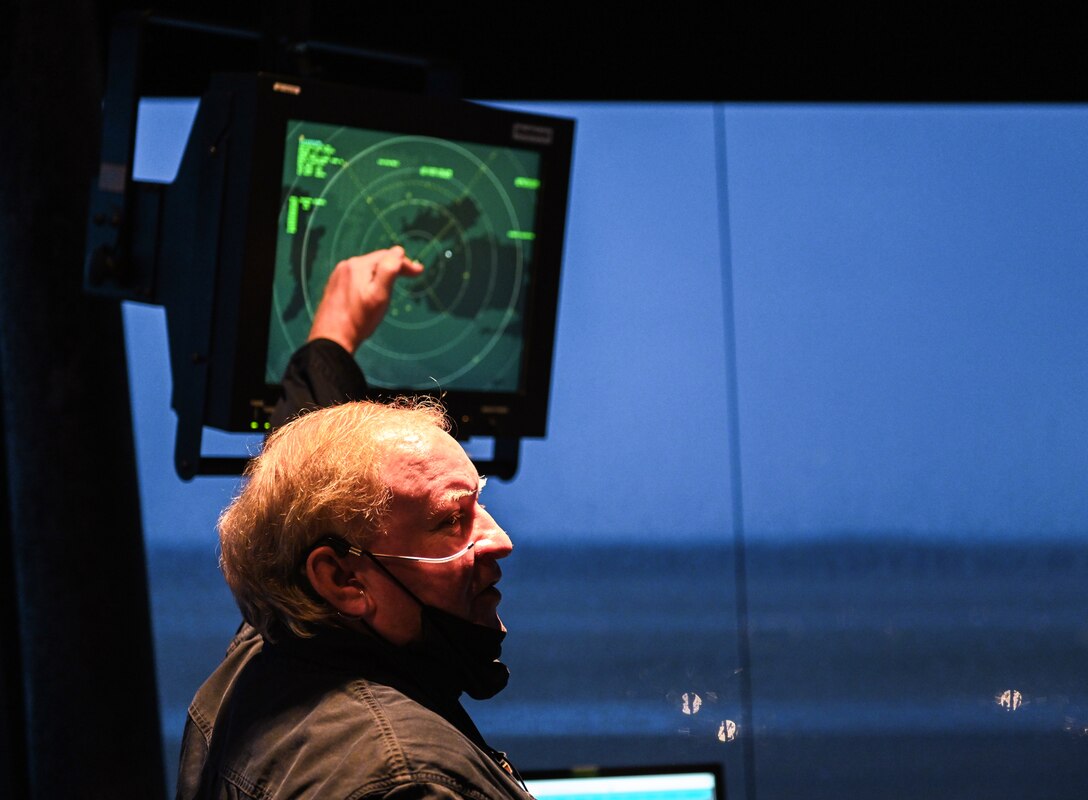 Retired U.S. Air Force Master Sgt. Walter Boltwood, Radar Approach Control (RAPCON) chief controller, points to a radar and chats with his peers on Jan. 7, 2020, at Columbus Air Force Base, Miss. Responsible for managing the flow of aircraft through all aspects of their flight, Air Traffic Control specialists ensure the safety and efficiency of air traffic on the ground and in the air. (U.S. Air Force photo by Airman 1st Class Davis Donaldson)