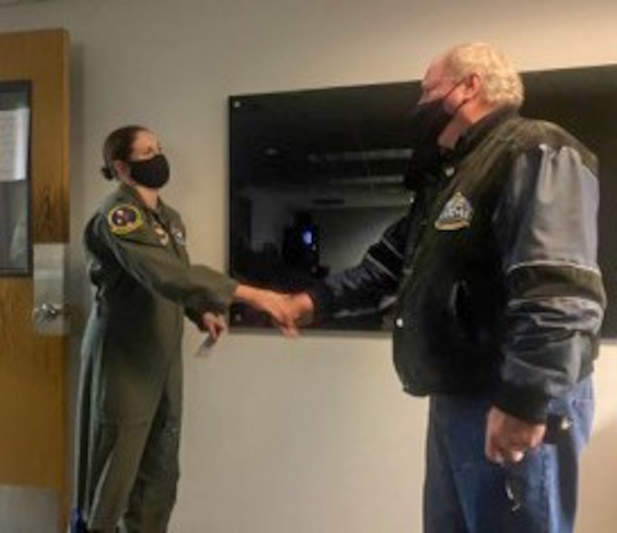 U.S. Air Force Lt. Col. Jennifer Prouty, 14th Operations Support Squadron commander, shakes hands with, Retired U.S. Air Force Master Sgt. Walter Boltwood, Radar Approach Control (RAPCON) chief controller on Jan. 7, 2020, at Columbus Air Force Base, Miss. The photo was taken shortly after Prouty taxied on the flightline and Boltwood cleared her for takeoff. (Courtesy photo)