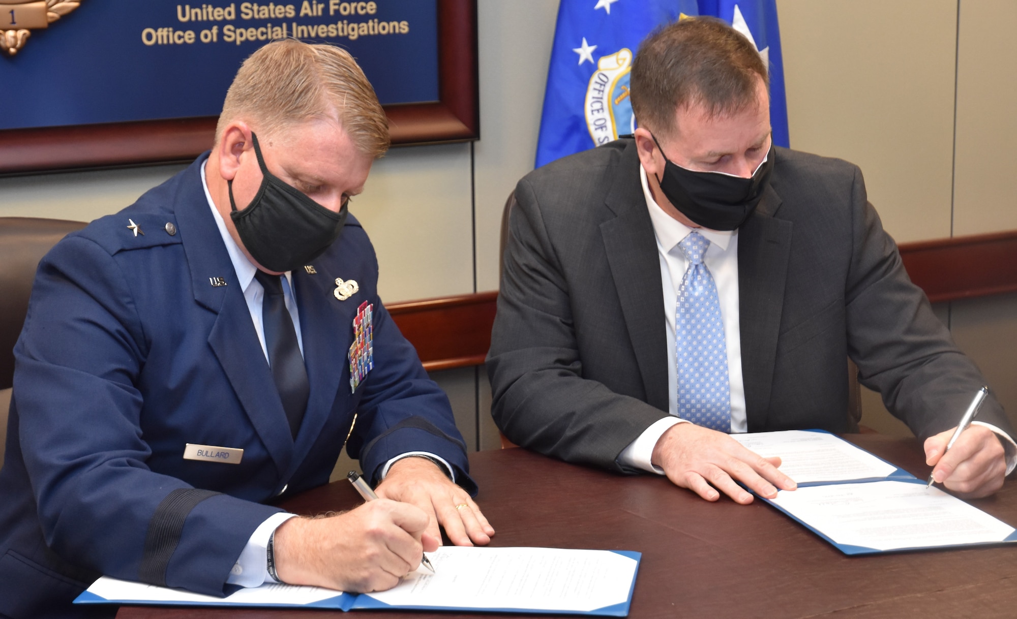 Office of Special Investigations Commander, Brig. Gen. Terry L. Bullard, and Department of Defense Cyber Crime Center Executive Director, Mr. Jeffrey D. Specht, sign documents during a ceremony Jan. 20, 2021, at OSI Headquarters observing the establishment of DC3 as a Field Operating Agency. (Photo by Special Agent Spencer King)