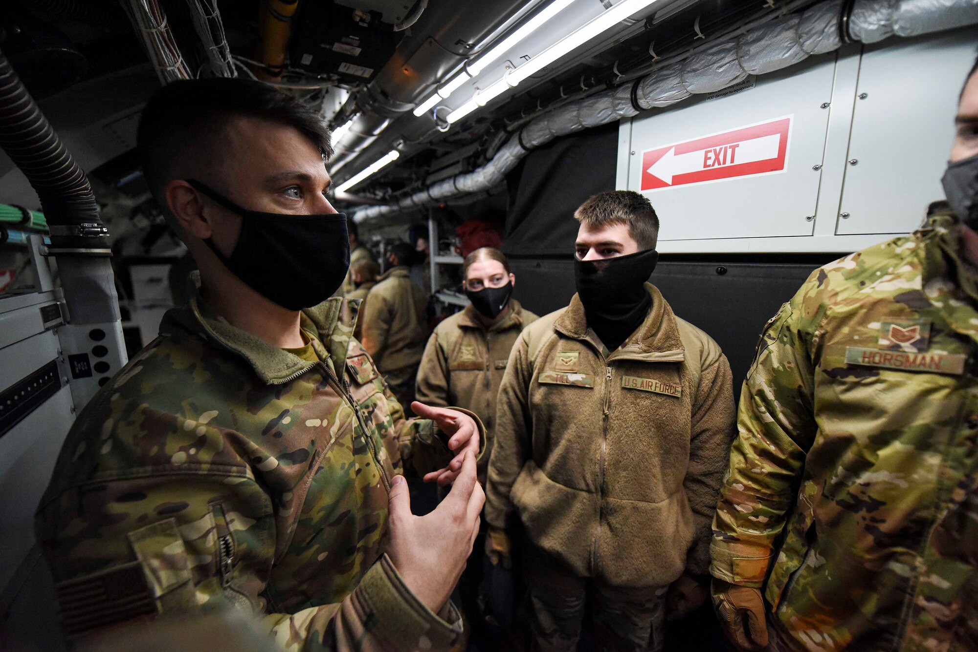 Security forces members listen to a RC-135S Cobra Ball team member Dec. 18, 2020, on Eielson Air Force Base, Alaska. During the holiday season a Cobra Ball crew allowed service members and base leadership to learn about the RC-135S mission. (U.S. Air Force photo by Senior Airman Keith Holcomb)
