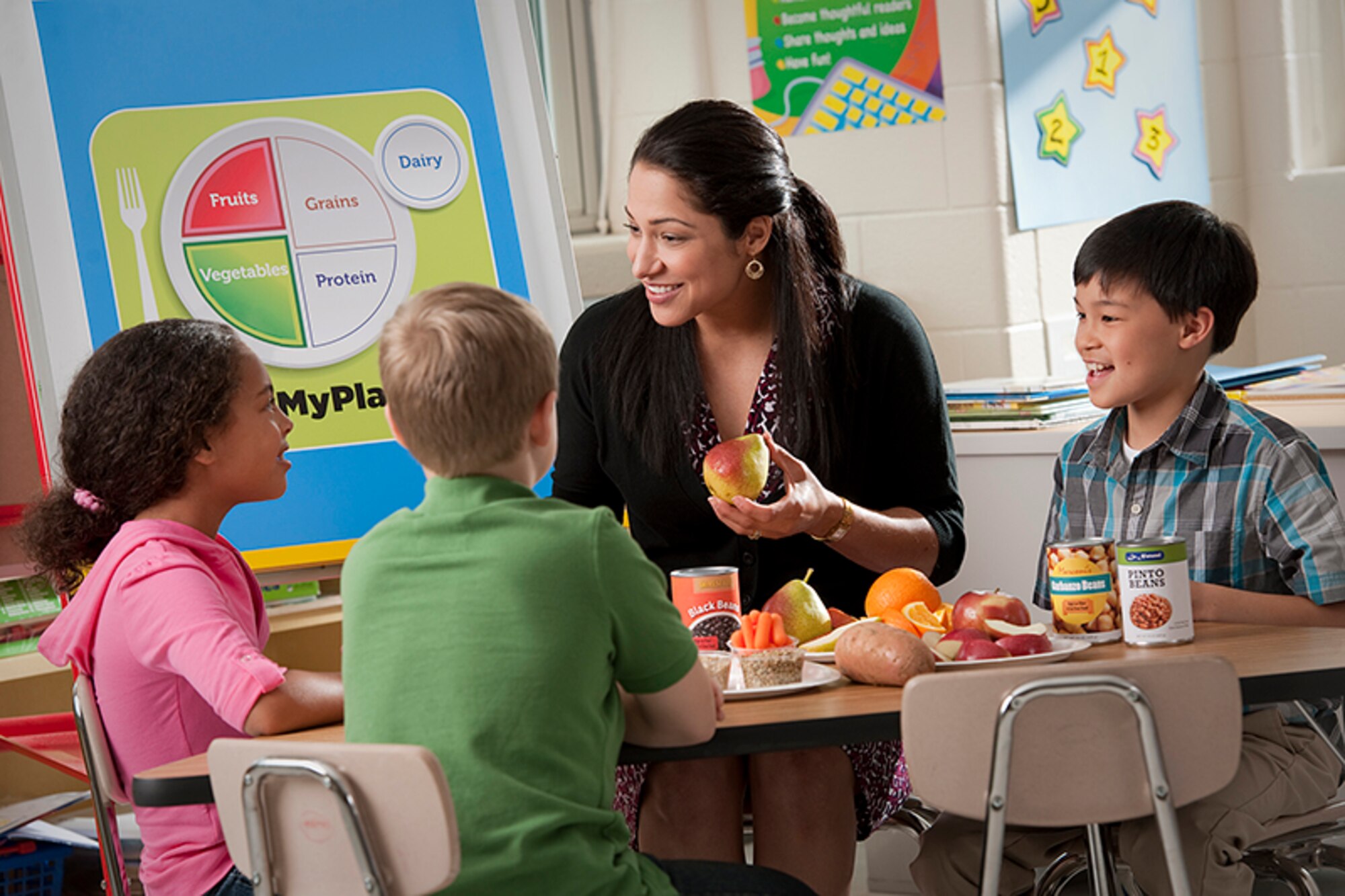 Woman eating with children with apple in her hands