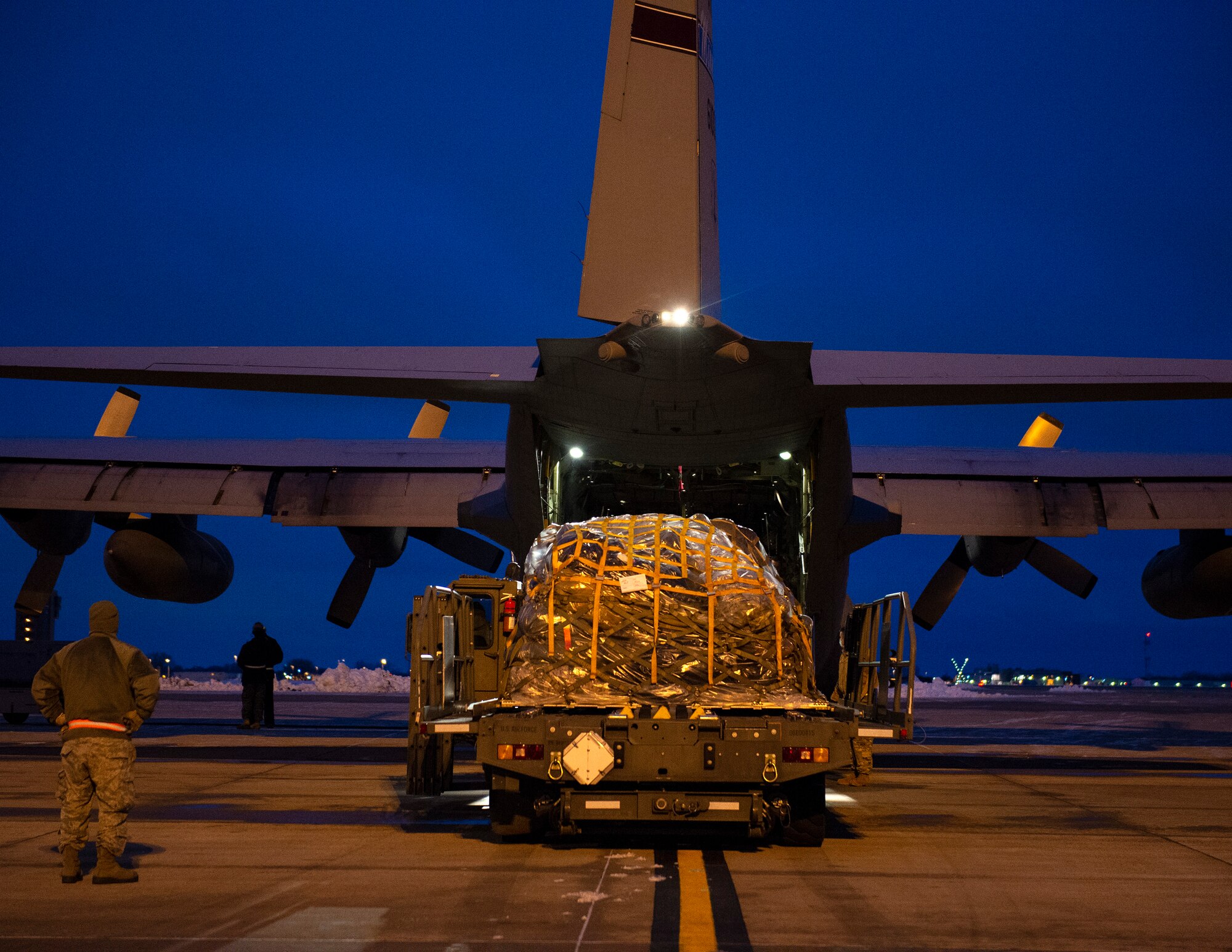U.S. Air Force Airman from the 133rd Air Transportation Function waits to load a C-130 Hercules with cargo in St. Paul, Minn., Jan. 18, 2021.