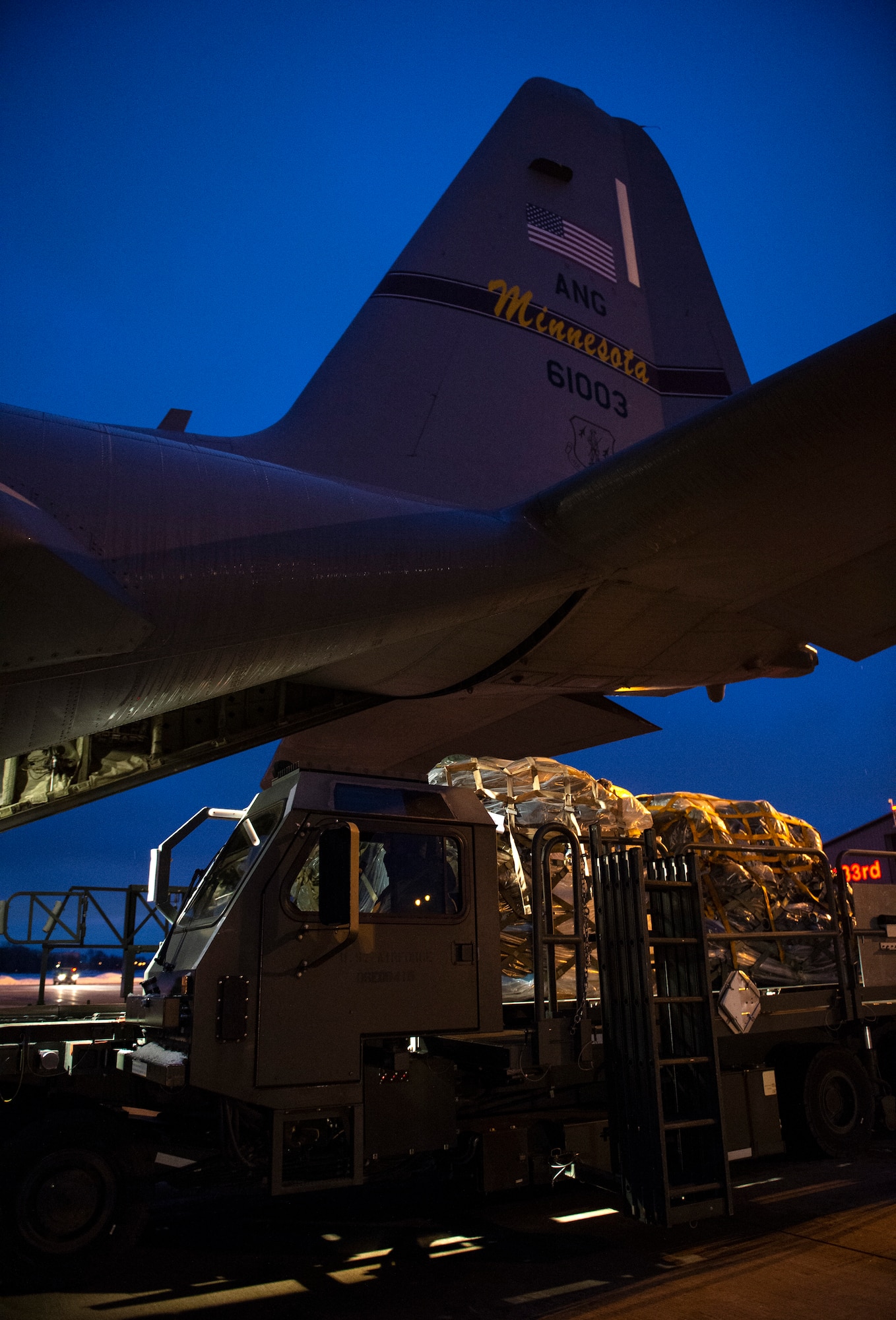 U.S. Air Force Airman from the 133rd Air Transportation Function waits to load a C-130 Hercules with cargo in St. Paul, Minn., Jan. 18, 2021.