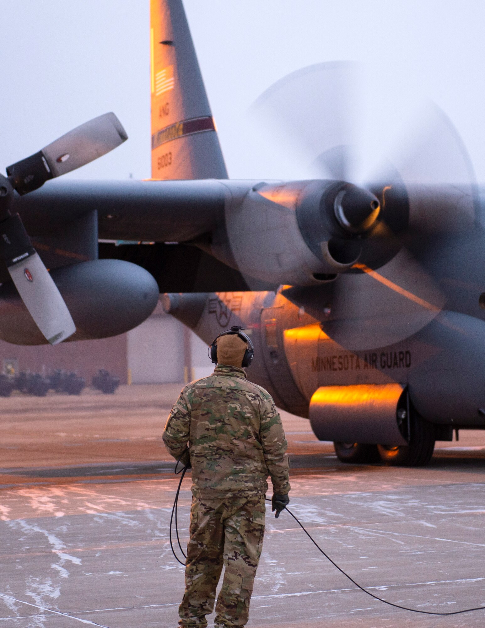 A loadmaster with the 109th Airlift Squadron watches C-130 Hercules start their engines in St. Paul, Minn., Jan. 18, 2021.