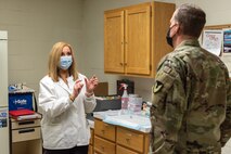 Photo of Debra Generose providing COL John McDonald with an update on workforce vaccinations.