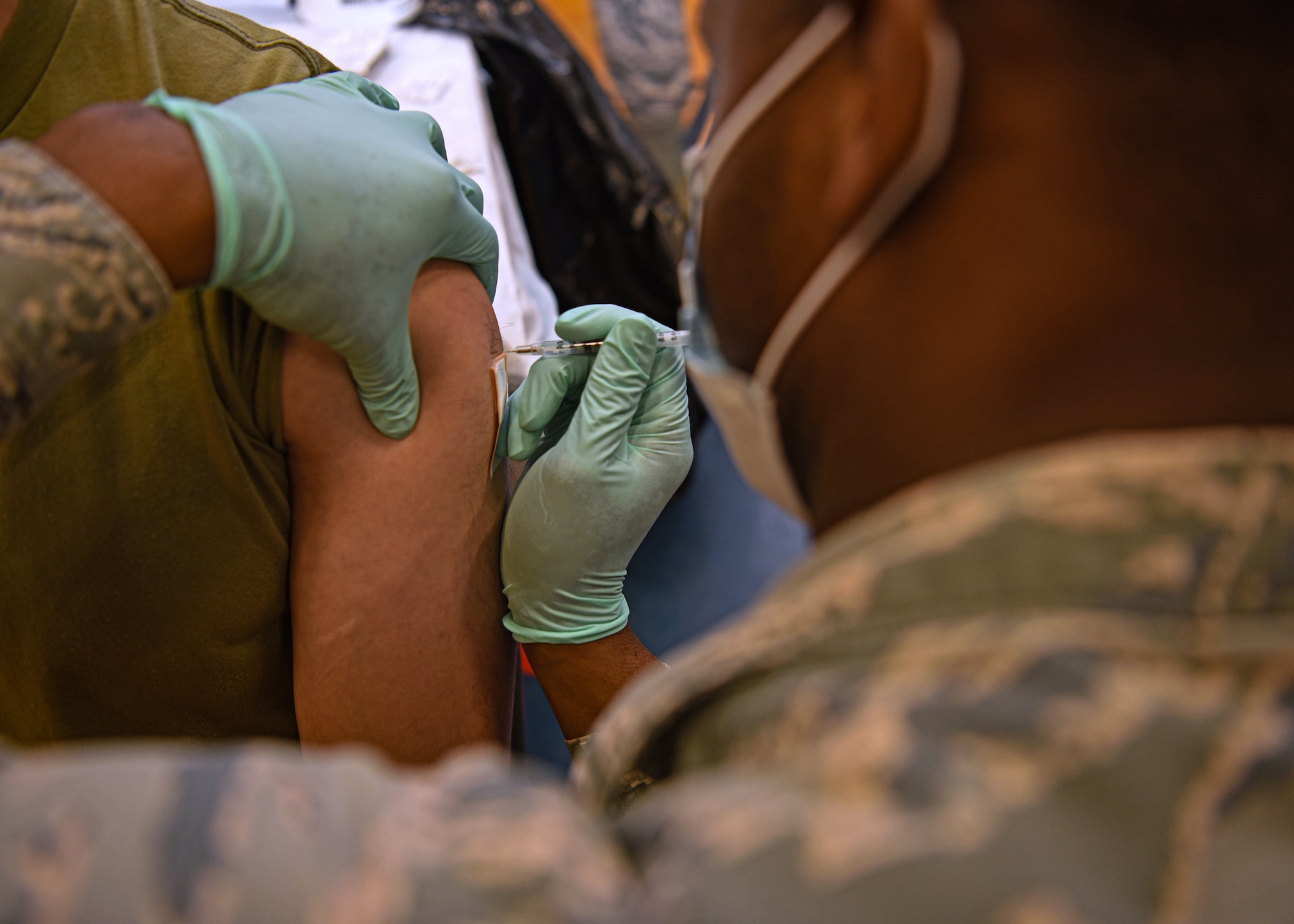 U.S. Air Force Senior Airman Marckus Humphries, 17th Operational Medical Readiness Squadron aerospace medical technician, administers a COVID-19 vaccination to Airman 1st Class Brandon Krogman, 17th Security Force Squadron defender, at the Mathis Fitness Center on Goodfellow Air Force Base, Texas, Jan. 20, 2021. Team Goodfellow vaccinated its frontline and mission essential positions, and those who are considered high risk first, in accordance with the Department of the Air Force’s distribution plan. (U.S. Air Force photo by Senior Airman Abbey Rieves)