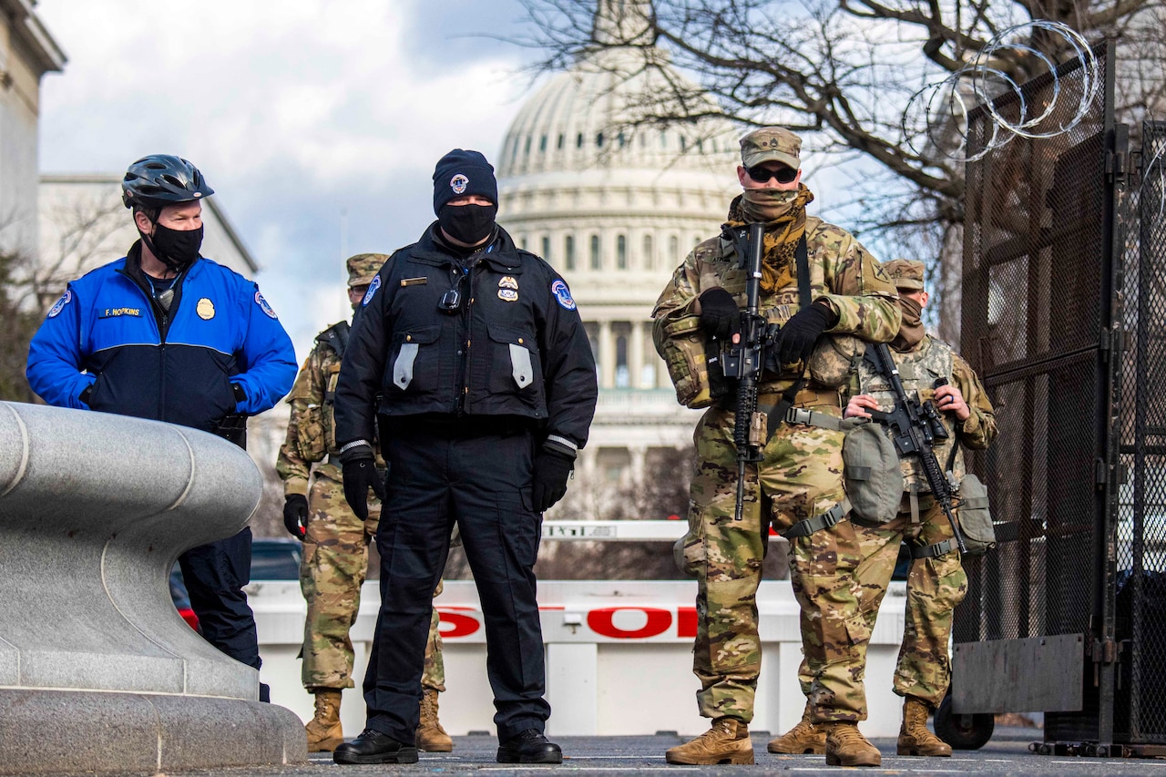 Guardsmen stand in front of the U.S. Capitol.