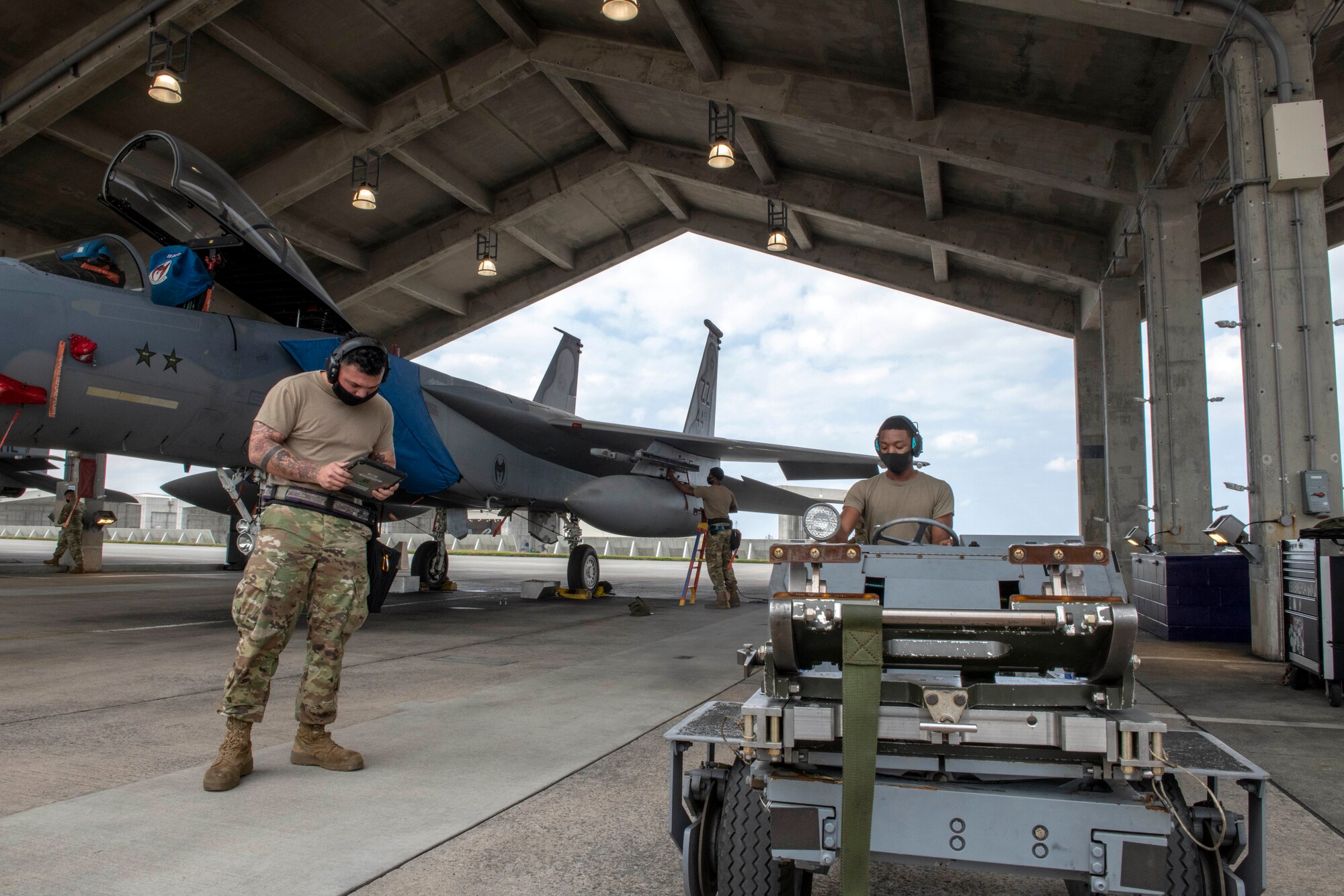 U.S. Air Force load crew members from the 44th Aircraft Maintenance Unit work together during the quarterly weapons load competition at Kadena Air Base, Japan, Jan. 14, 2021. Weapons Load crew competitions are held each quarter and annually in order to boost morale and highlight superior performers among the load crew teams. (U.S. Air Force photo by Naoto Anazawa)