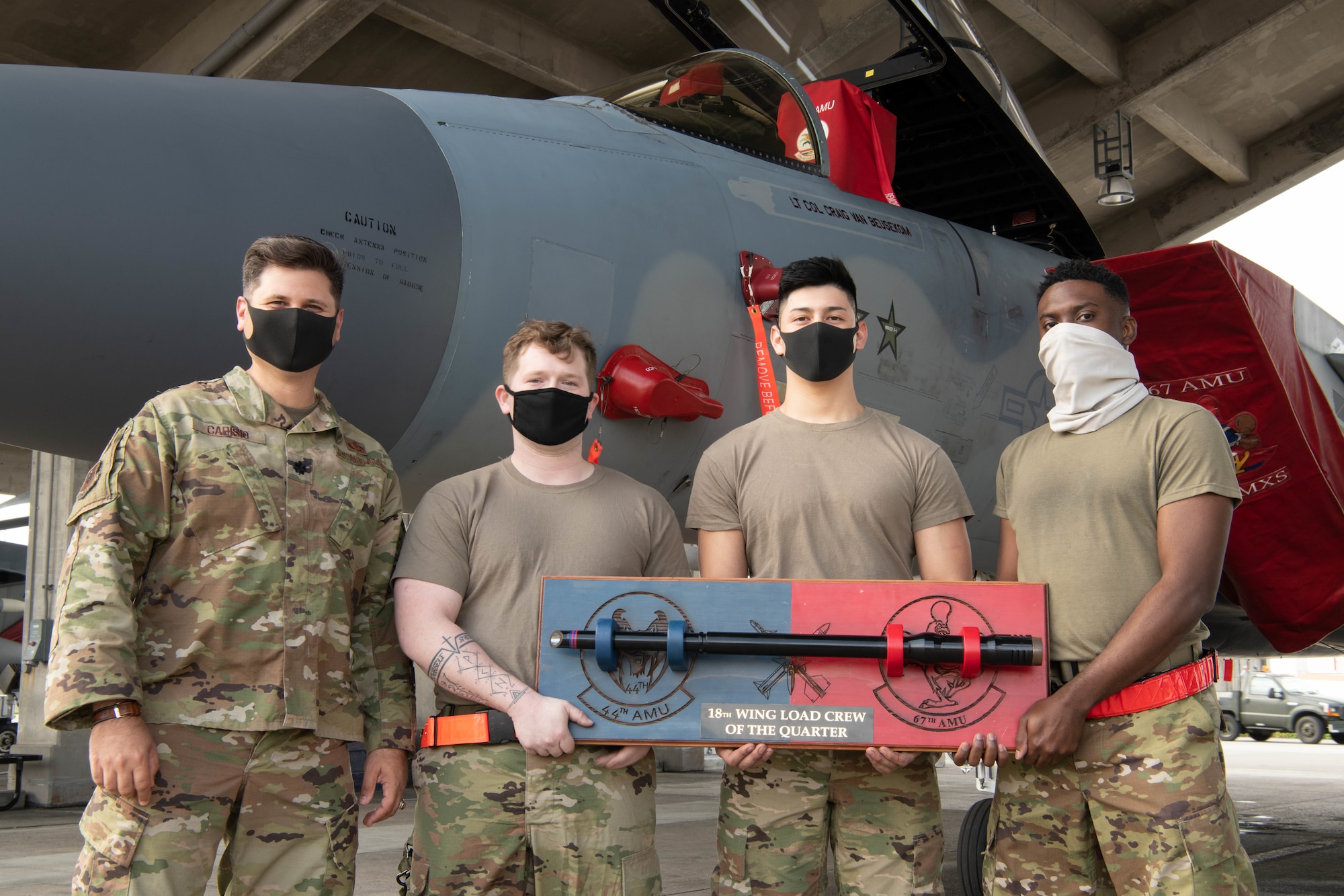 U.S. Air Force Lt. Col. Gerard Carisio, the 18th Maintenance Group deputy commander, and load crew members from the 67th Aircraft Maintenance Unit pose with the load competition trophy in front of an F-15C Eagle at Kadena Air Base, Japan, Jan. 15, 2021. The 67th AMU won the quarterly load competition against the 44th AMU. (U.S. Air Force photo by Airman First Class Stephen Pulter)