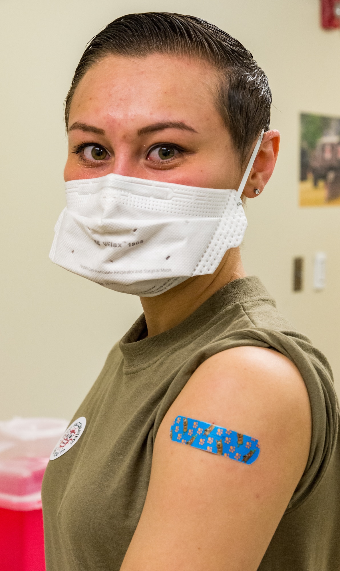 Senior Airman Bianca Robichaud, 436th Health Care Operations Squadron acting family health noncommissioned officer in charge, poses for a photo after receiving the COVID-19 vaccine administered by Staff Sgt. Kelsey Loeser, 436th 436th Medical Group unit training manager, Jan. 15, 2021, at Dover Air Force Base, Delaware. Robichaud was the first person on Dover AFB to receive the COVID-19 vaccine. The vaccine was granted emergency use authorization by the U.S. Food and Drug Administration for use in prevention of the COVID-19. (U.S. Air Force photo by Roland Balik)