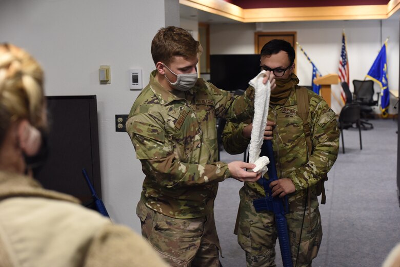 Two convoy team leaders are up-wrapping gauze in preparation for a Tactical Combat Casualty Care simulation in where newly taught medical skills will be put to the test.