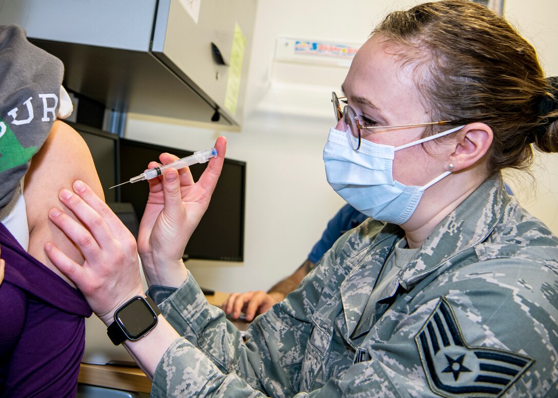 Staff Sgt. Morgan Mack, 423rd MDS NCO in charge of immunizations, administers the COVID-19 vaccine to a Department of Defense Education Activity teacher at RAF Alconbury, England, Jan. 7, 2020. Department of Defense Education Activity teachers are receiving the vaccine in an effort to reduce the potential spread of COVID-19 within the schools and community. (U.S. Air Force photo by Senior Airman Eugene Oliver)
