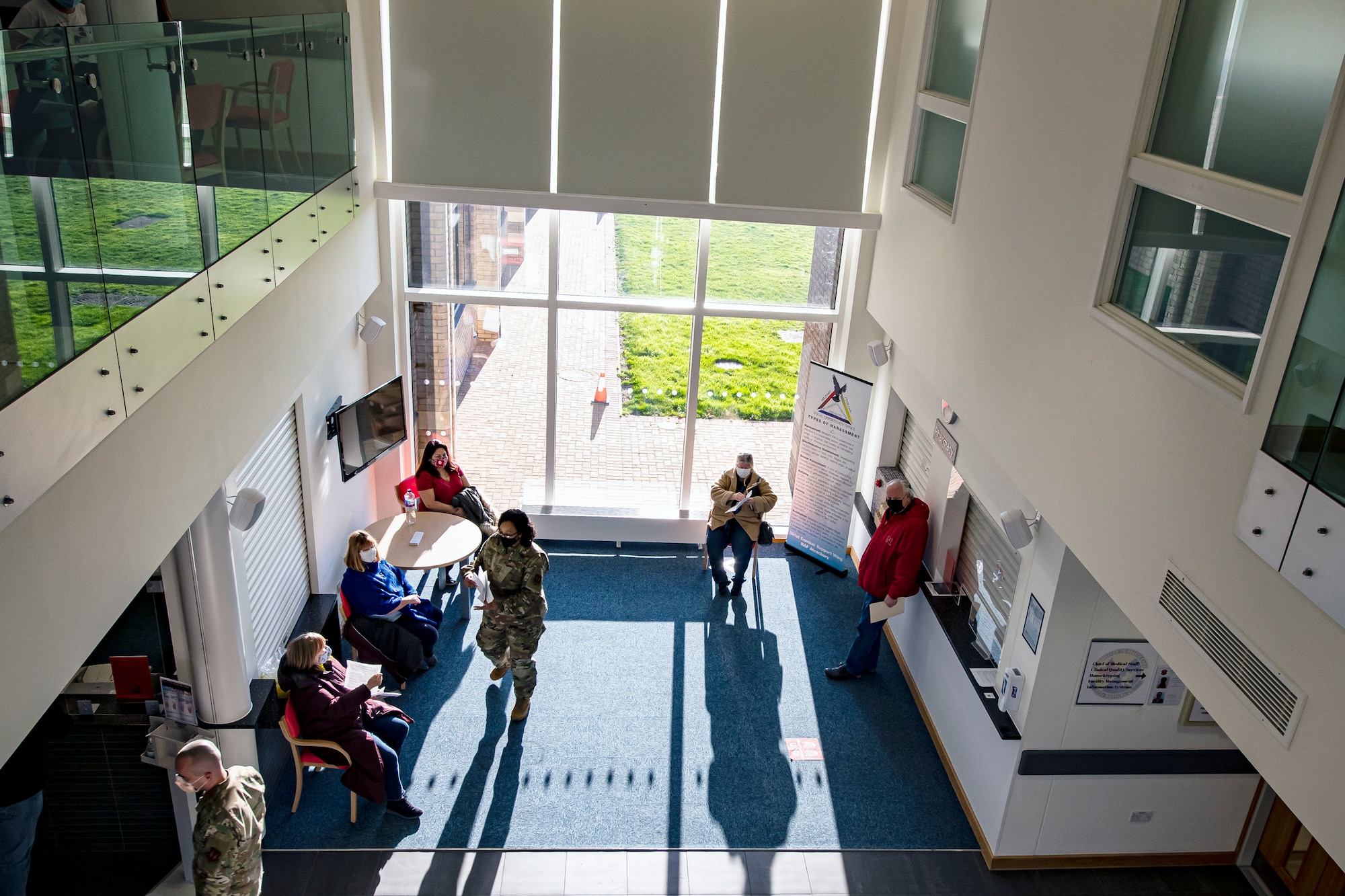 Department of Defense Education Activity teachers, wait in the lobby of the 423rd Medical Squadron clinic, prior to receiving the COVID-19 vaccine at RAF Alconbury, England, Jan. 7, 2020. DoDEA teachers are receiving the vaccine in an effort to reduce the potential spread of COVID-19 within the schools and community. (U.S. Air Force photo by Senior Airman Eugene Oliver)