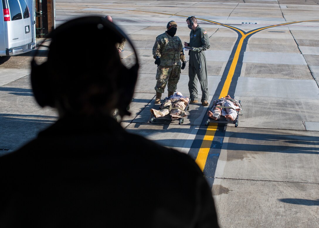 Capt. Rachel Pickich (foreground), flight nurse for the 36th Aeromedical Evacuation Squadron, stands ready to direct fellow 36th AES members to load patients onto a WC-130J during a pre-deployment training exercise at Keesler Air Force Base, Miss., Jan. 13, 2021. The 36th AES is tasked with the mission of caring for and transporting patients in the air until they can get to a medical facility that can accommodate their needs. (U.S. Air Force photo by Senior Airman Kristen Pittman)