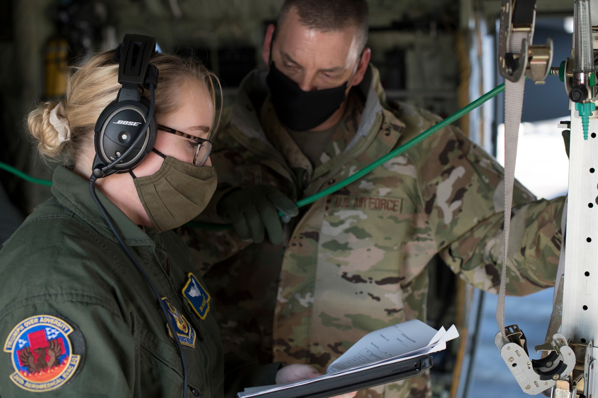 Senior Airman Madison Ross, 36th Aeromedical Evacuation Squadron flight medic, goes over a patient checklist with Senior Master Sgt. Anthony Staut, operations support flight chief for the 36th AES, before an aeromedical evacuation training flight at Keesler Air Force Base, Miss January 13, 2021. Ross is one of six Reservists who will be deploying to either Travis AFB, Calif. or Ramstein Air Base in Germany to assist in transporting and caring for COVID-19 patients. (U.S. Air Force photo by Senior Airman Kristen Pittman)