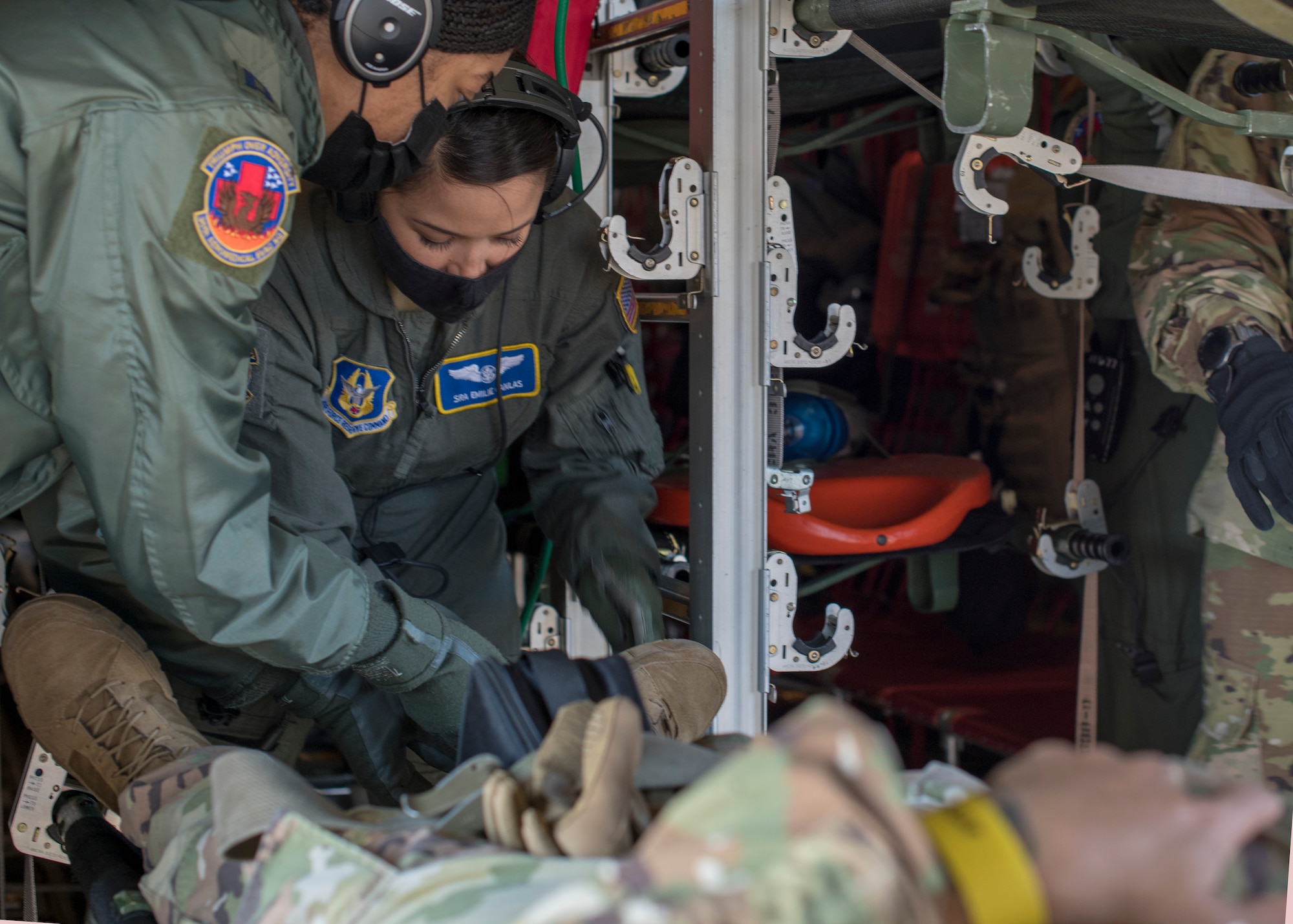 Capt. Toya Williams, 36th Aeromedical Squadron flight nurse, and Senior Airman Emilie Canlas, 36th AES flight medic, work together to secure a patient's litter during pre-deployment aeromedical evacuation training at Keesler Air Force Base, Miss., Jan. 13, 2021. The 36th AES is part of the Air Force Reserve's 403rd Wing. (U.S. Air Force photo by Senior Airman Kristen Pittman)