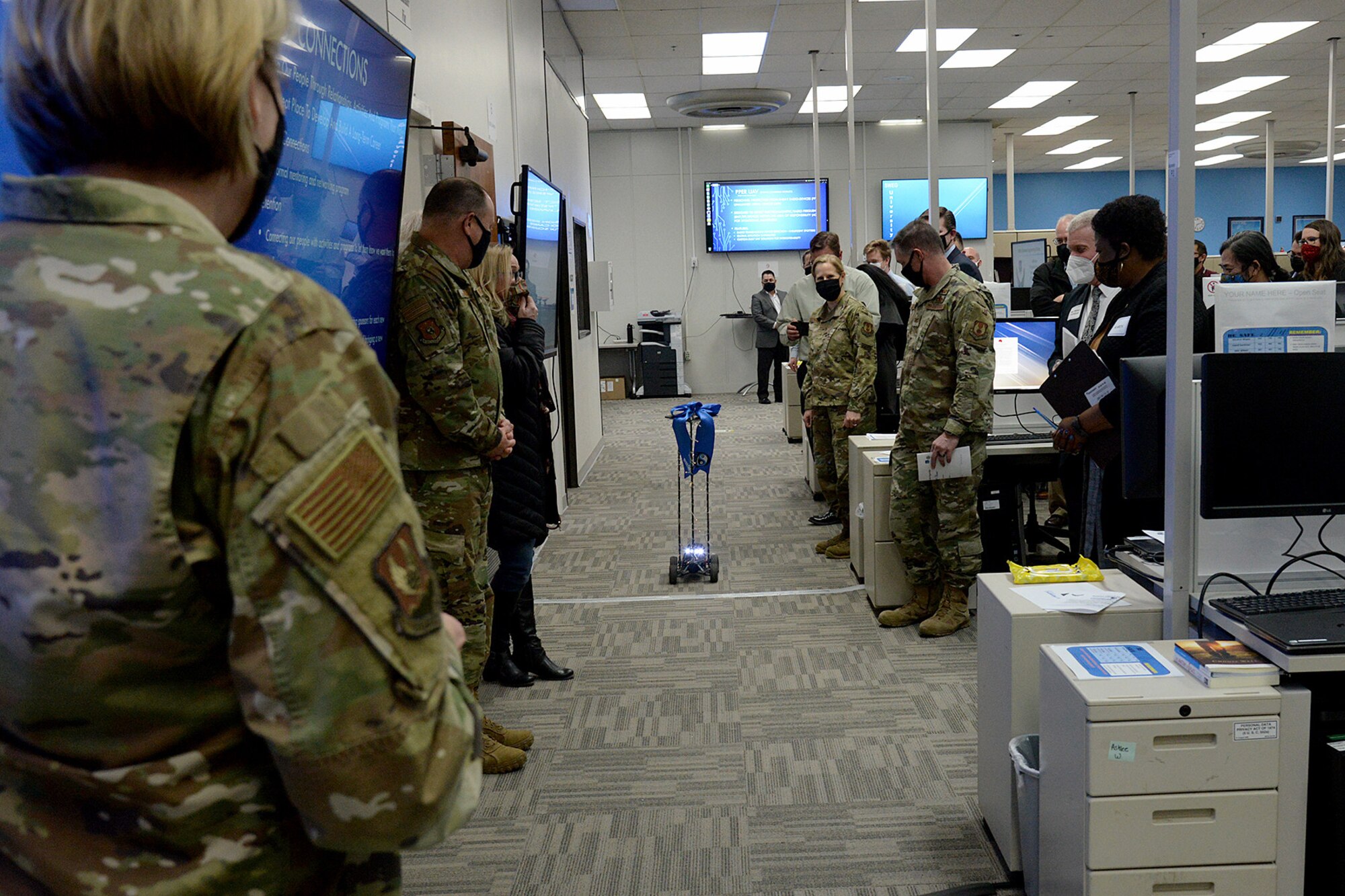 A remote controlled car delivers scissors to Brig. Gen. Cauley von Hoffman, Ogden Air Logistics Complex commander.