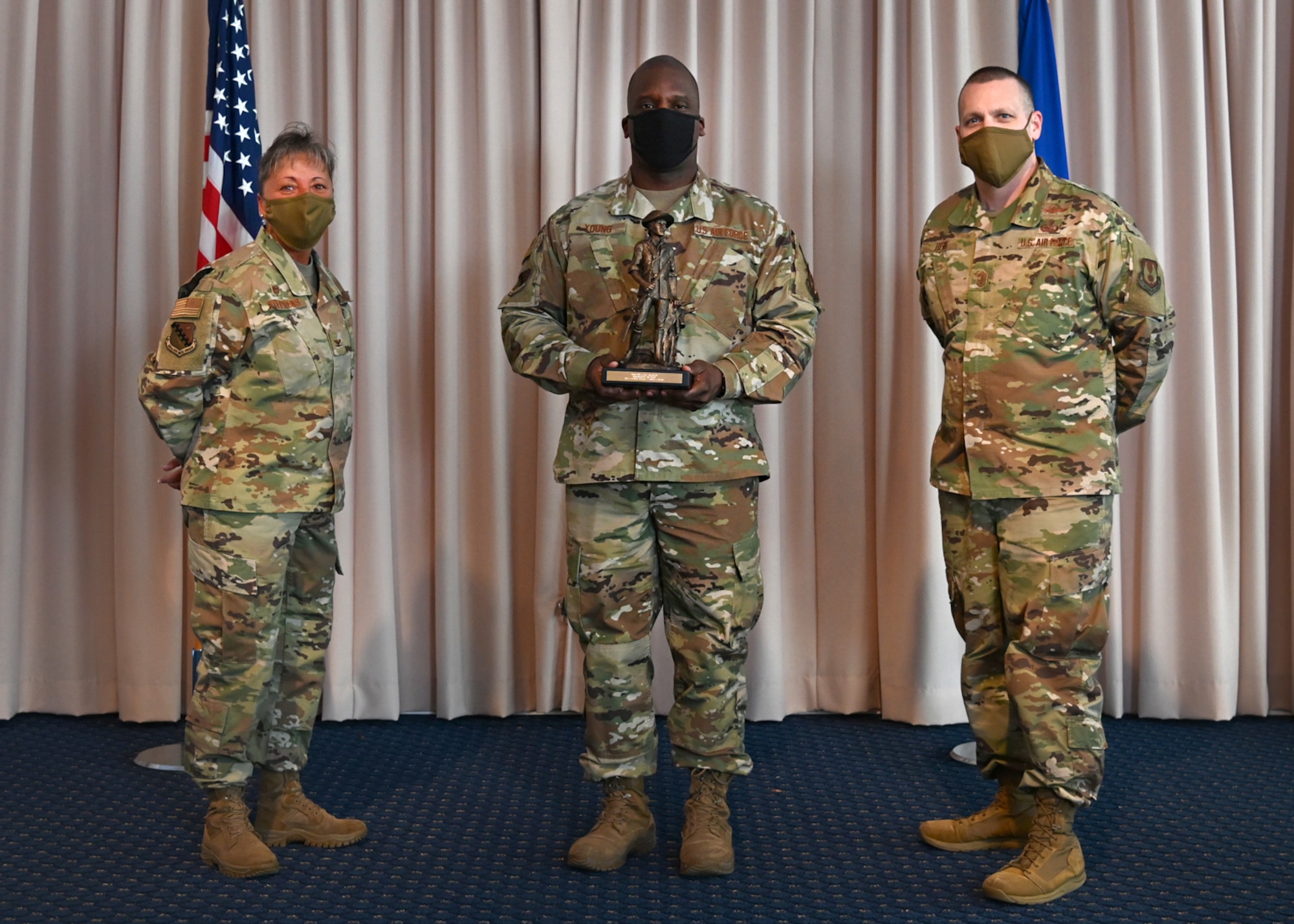 Col. Katrina Stephens, 66th Air Base Group commander, and Chief Master Sgt. Bill Hebb, 66 ABG command chief, present Master Sgt. Ronald Young, 66 ABG Inspector General superintendent, with the 2020 Senior Noncommissioned Officer of the Year award at Hanscom Air Force Base, Mass., Jan 20.