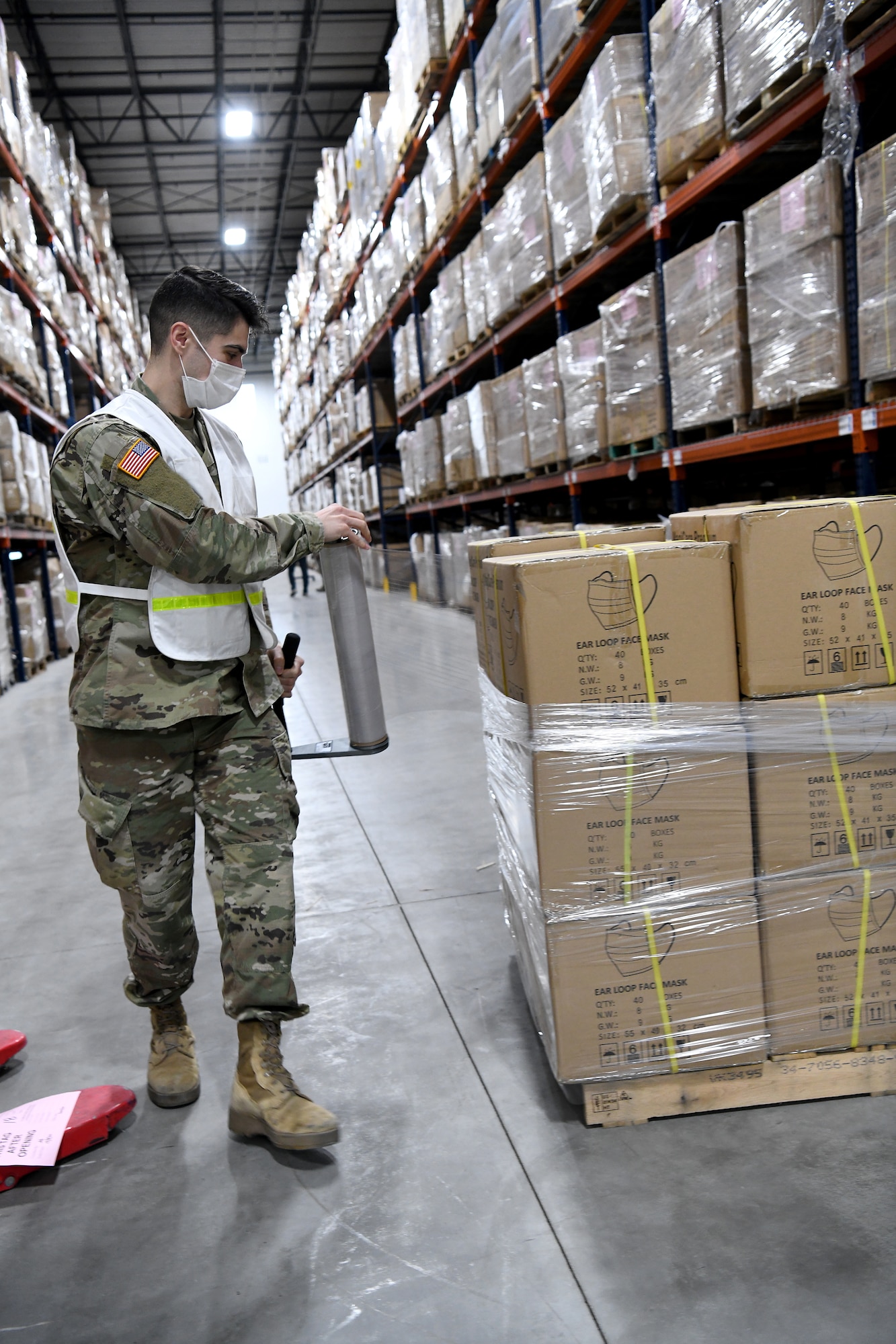 An Airmen uses plastic wrap to palletize supplies.