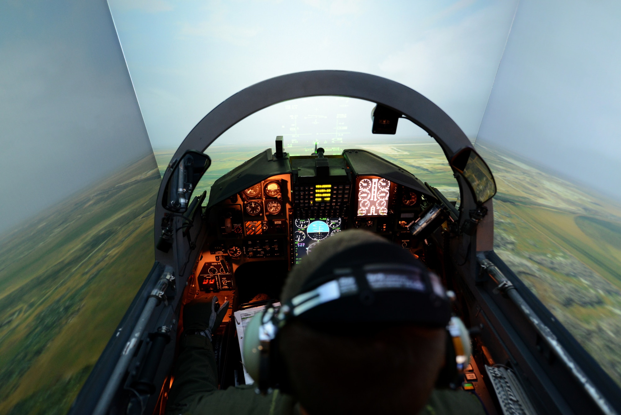 A pilot in training sits in a flight simulator.