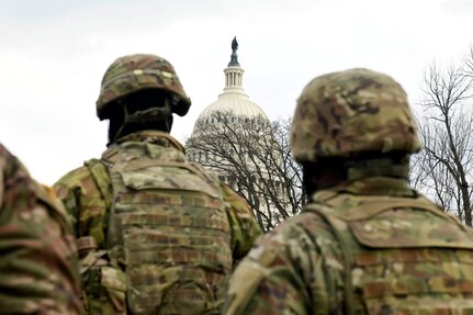 Soldiers and Airmen with the Virginia National Guard stand at attention at the U.S. Capitol during the 59th presidential inauguration in Washington, D.C., Jan. 20, 2021. More than 26,000 National Guard men and women conducted security, communication and logistical missions in support of federal and district authorities for the inauguration.